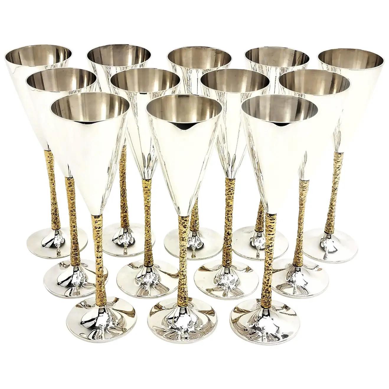 Introducing an exquisite collection of twenty-eight English parcel-gilt silver champagne flutes, masterfully crafted by the renowned Stuart Devlin in London between 1977 and 1981. Each flute bears distinctive markings on its base, denoting its