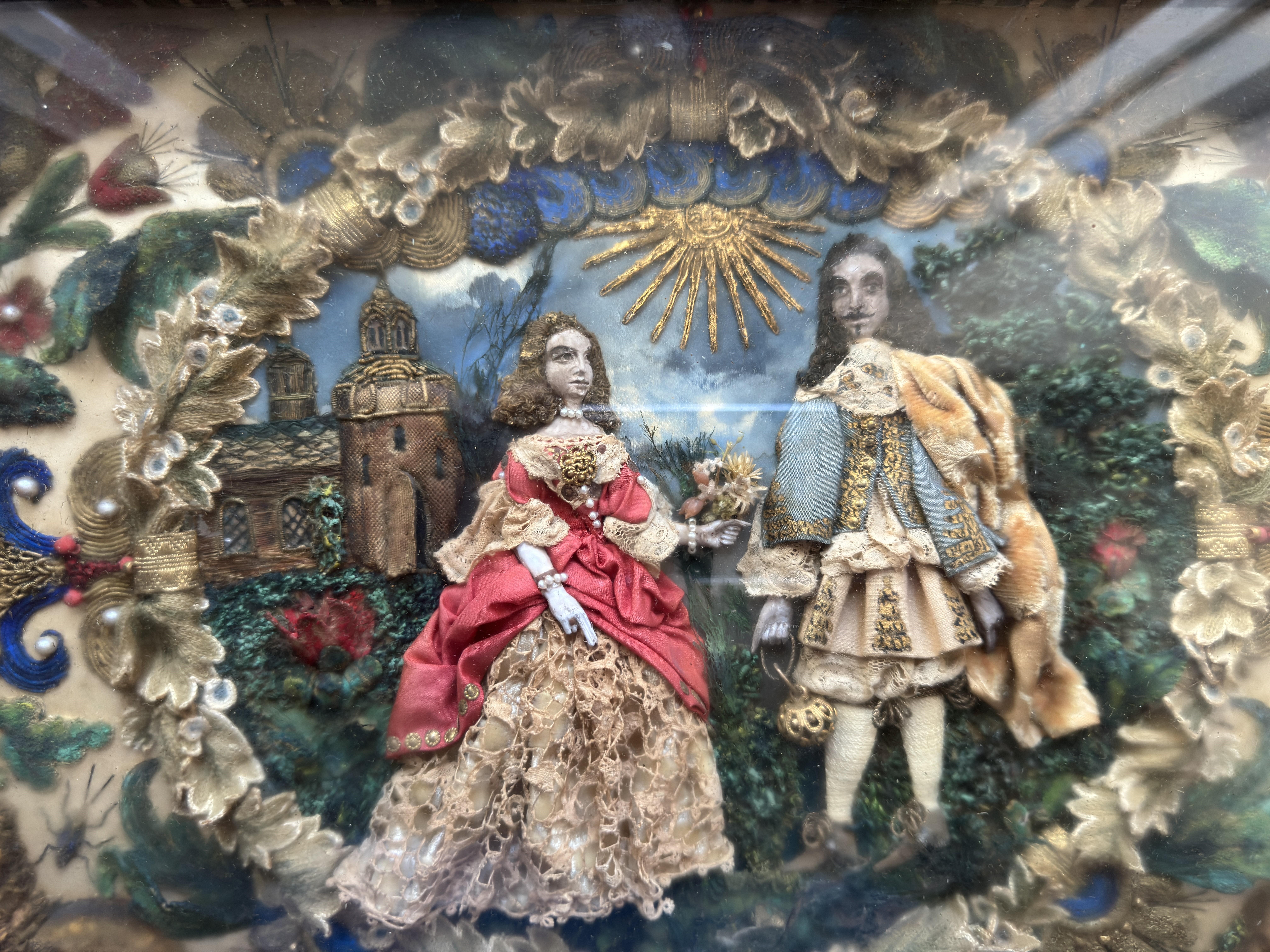 A very fine panel of 'King Charles II and his favourite Lady' in the gardens of a Church / Castle. The bright colours of the raised stump work embroidery, and fine detail of the faces, bring to life this antique textile picture. The back of the