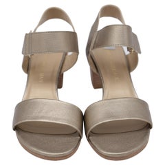 Sandali Stuart Weitzman con cinturino alla caviglia e tacco largo, in pelle dorata metallizzata