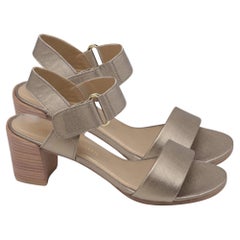 Sandali Stuart Weitzman con cinturino alla caviglia e tacco largo, in pelle dorata metallizzata