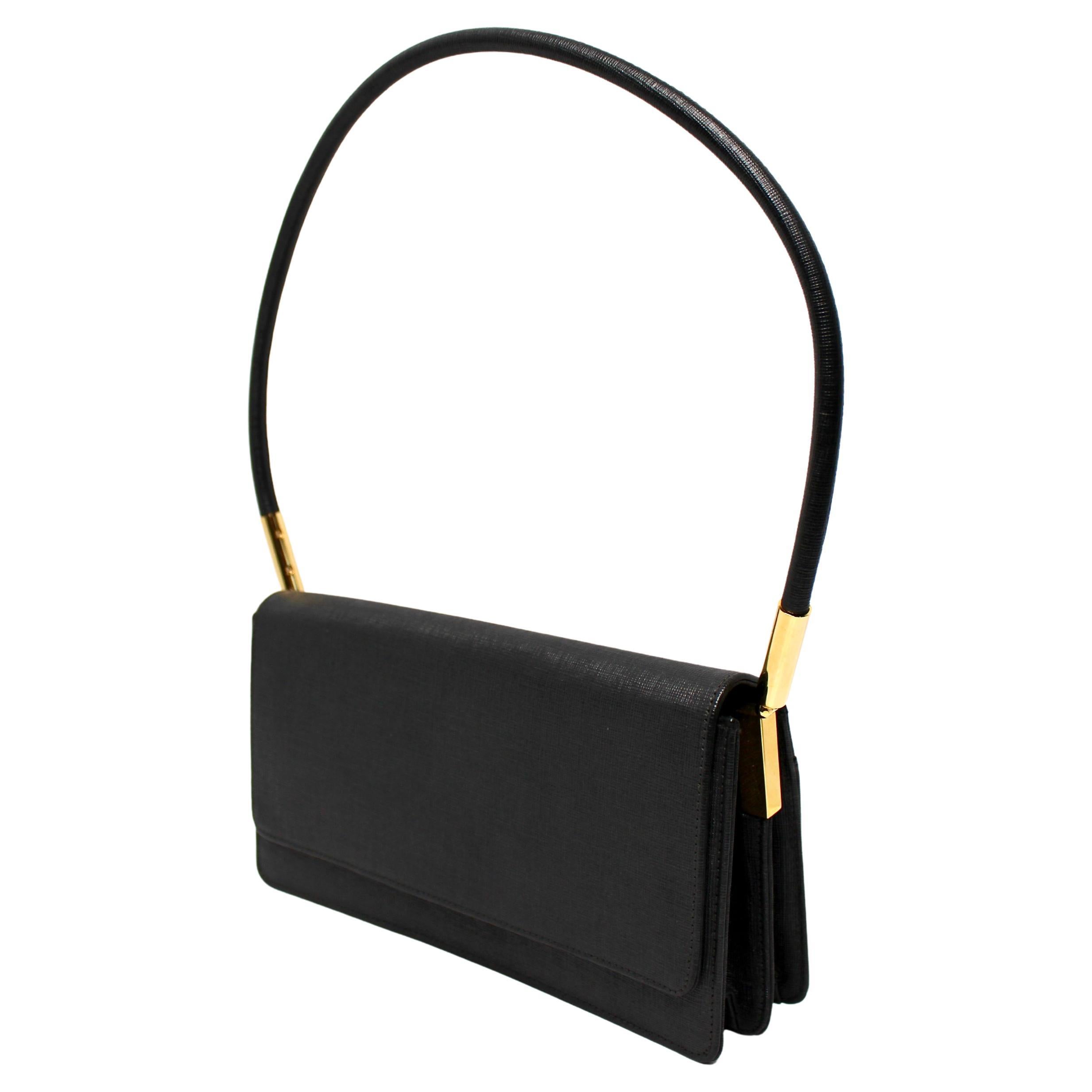 El Bolso de hombro estructurado con solapa negro de Stuart Weitzman de alrededor de los años 90 destila elegancia atemporal y sofisticación clásica. Fabricado en piel negra de alta calidad, este bolso presenta una silueta elegante y estructurada con