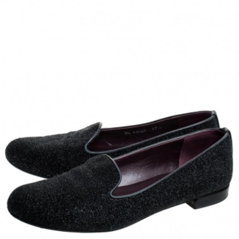 Diese flachen Schuhe von Stuart Weitzman sind stilvoll und sorgen für Glamour. Sie sind aus Glitzerleder gefertigt und in Schwarz gehalten. Sie zeichnen sich durch luxuriöse Lederbesätze, Futter, Innensohlen und Sohlen aus. Sie sind bequem,