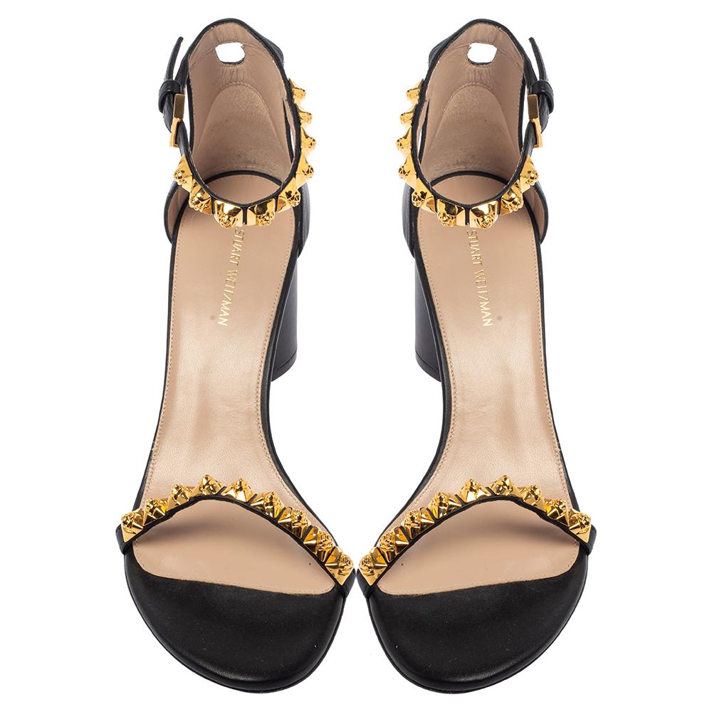 These black sandals from Stuart Weitzman are made from leather into a gorgeous design. They feature a single strap to secure the toes and another strap around the ankle — both are embellished with gold-tone studs. Complete with block heels to lift