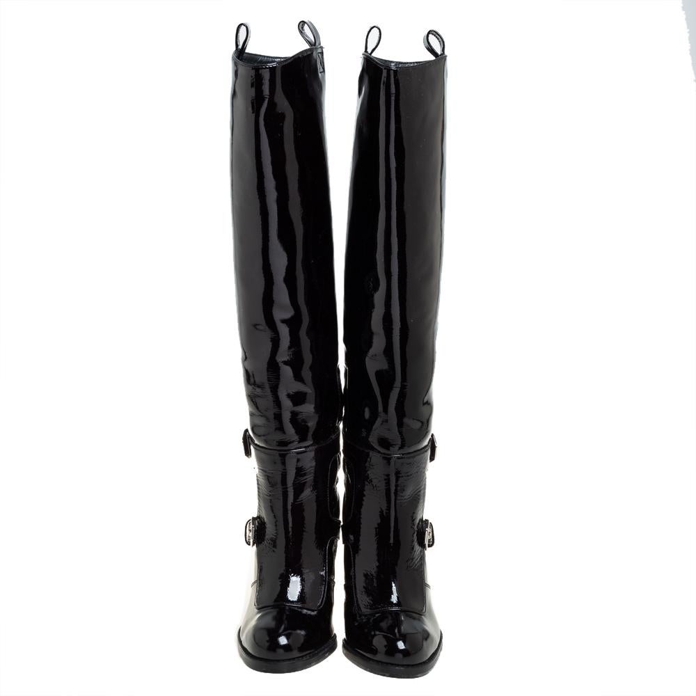 These Stuart Weitzman boots are a reflection of the label's immaculate artistry in shoemaking. Made from patent leather in a knee-length design, they are adorned with buckles, a black shade, and raised on block heels.

Includes: Original Dustbag,