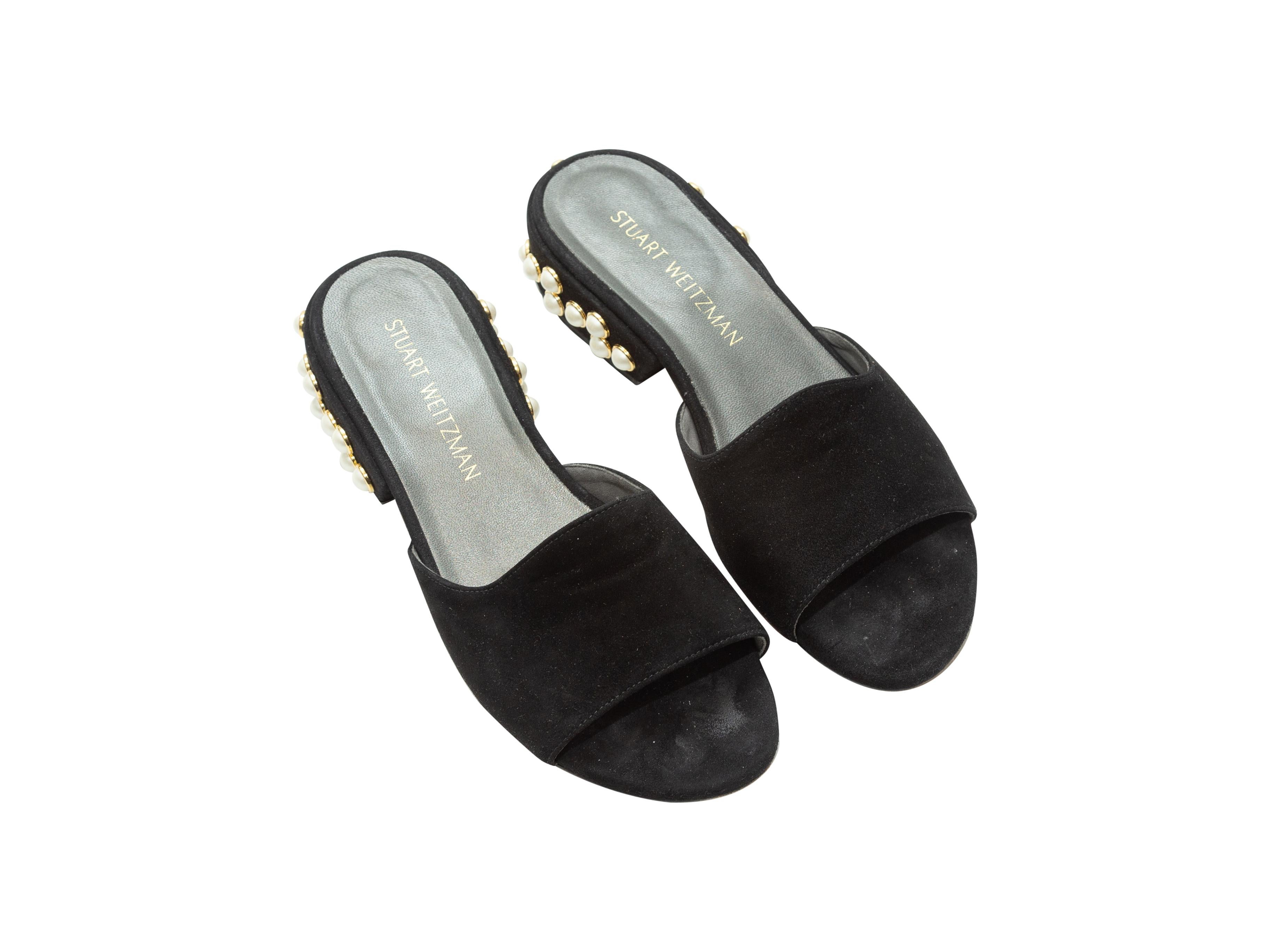 Product details: Black suede slide sandals by Stuart Weitzman. Faux pearl embellishments at block heels.
Condition: Pre-owned. Very good. Minor wear at inner soles.
Est. Retail $ 495.00