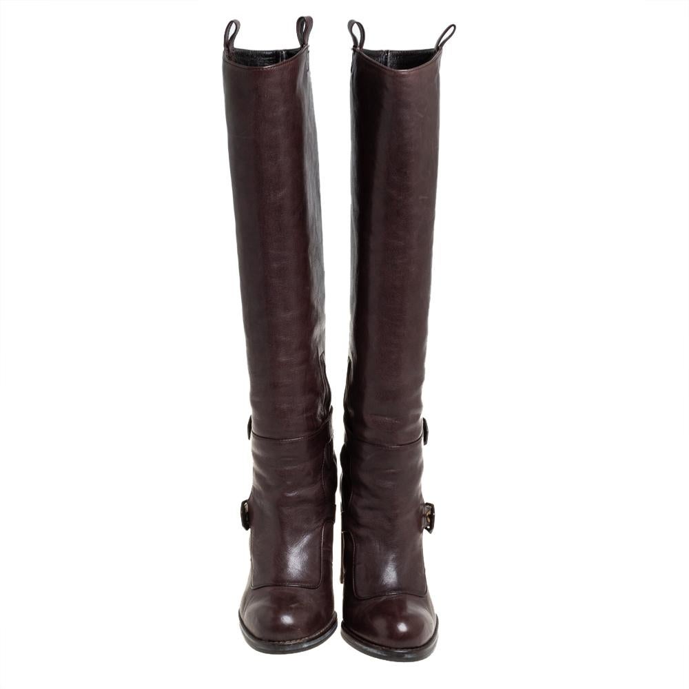 These Stuart Weitzman boots are a reflection of the label's immaculate artistry in shoemaking. Made from leather in a knee-length design, they are adorned with buckles, a brown shade, and raised on block heels.

Includes: Original Dustbag, Original