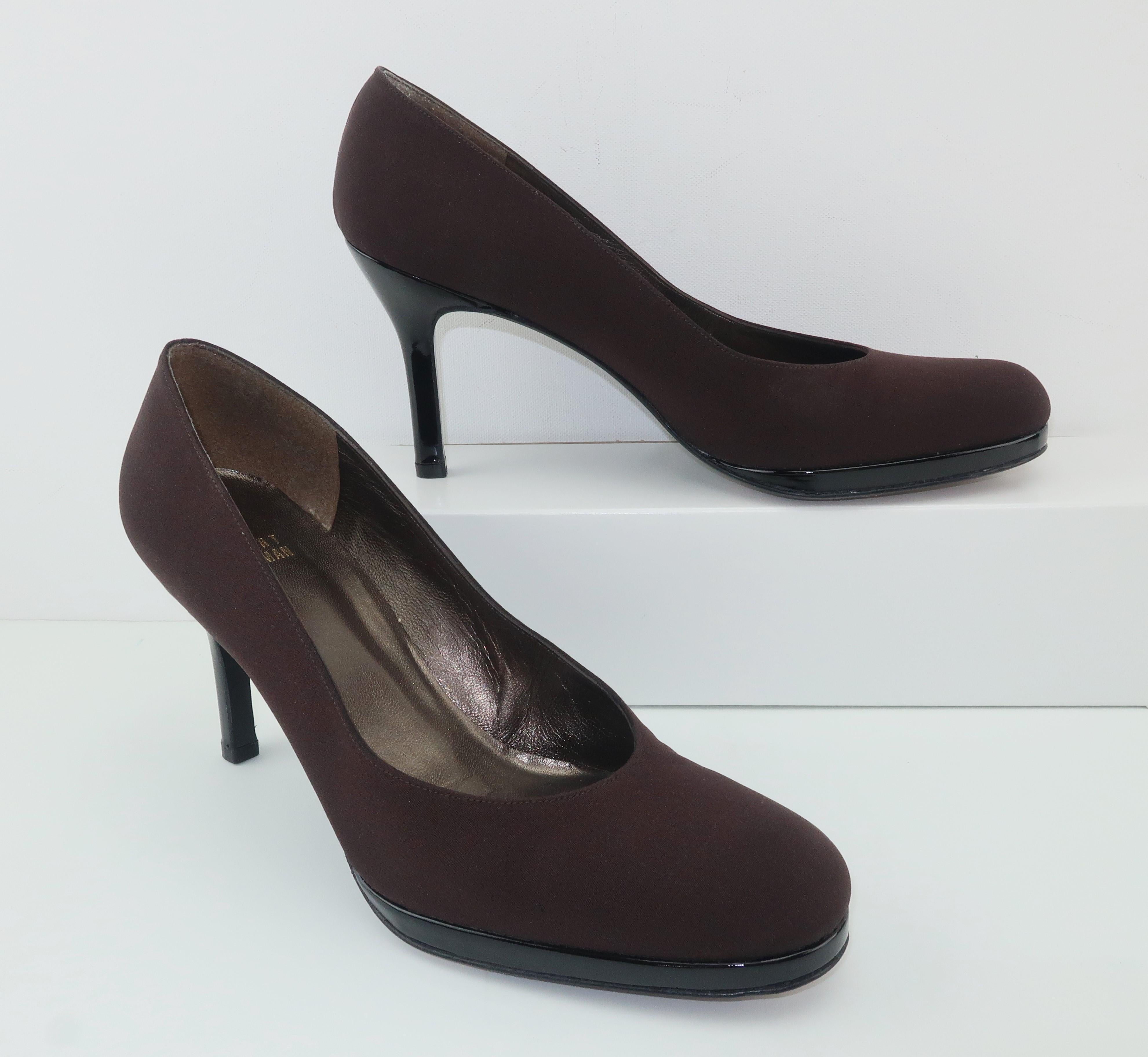 A classic and comfortable shoe by Stuart Weitzman in a dark chocolate brown silk faille accented with a black patent leather modest platform and heel.  These shoes are versatile enough to take you from daytime to evening wear easily dressing up a