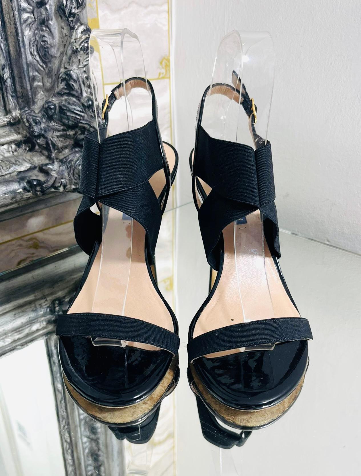 Stuart Weitzman Cross Strap Patent Leather Sandals

Black 'Alana' sandals designed with open round toes and buckled ankle strap.

Featuring wide, elastic straps to the top and single, thin strap to the vamp.

Styled with stiletto heel and leather