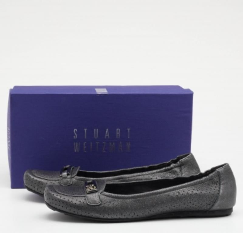 Mit diesen Loafers von Stuart Weitzman zeigen Sie unendlich viel Klasse und Raffinesse. Sie sind aus metallisch-grauem, perforiertem Leder gefertigt, das sich auf der Außenseite befindet. Sie sind zum Hineinschlüpfen und haben eine Metallbeschläge