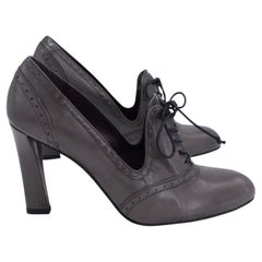 Décolleté con allacciatura e punta a ala di Stuart Weitzman in pelle grigia