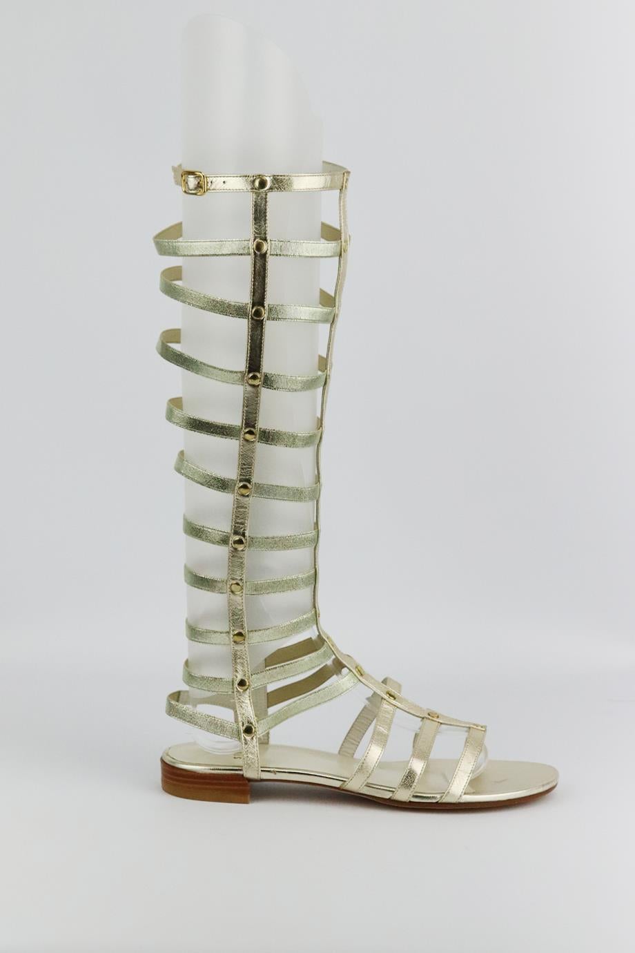 Stuart Weitzman metallic leather knee high sandals. Made from gold leather with gold-tone studded detail. Gold. Zip fastening at side. Does not come with box and dustbag. Size: EU 38 (UK 5, US 8). Shaft: 14.2 in. Insole: 9.8 in. Heel: 0.8 in
