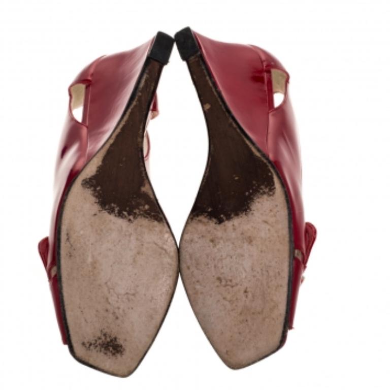 Be in full comfort with these Stuart Weitzman pumps. They are made from patent leather and feature open toes, 7.5 cm wedge heels and buckle detailing on the vamps. The insoles are leather-lined.