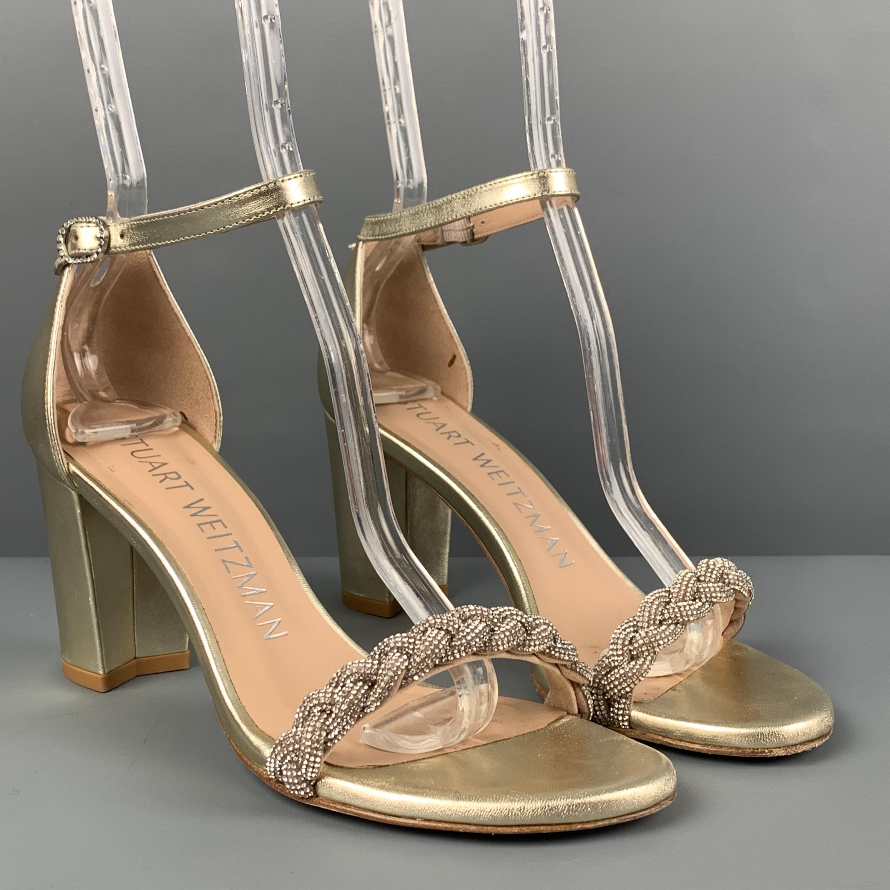 STUART WEITZMAN sandals comes in a platinum silver leather featuring a braided rhinestone detail, chunky heel, and a ankle strap closure. Comes with dust bag. Made in Spain. 

Very Good Pre-Owned Condition.
Marked: 6.5
Original Retail Price: