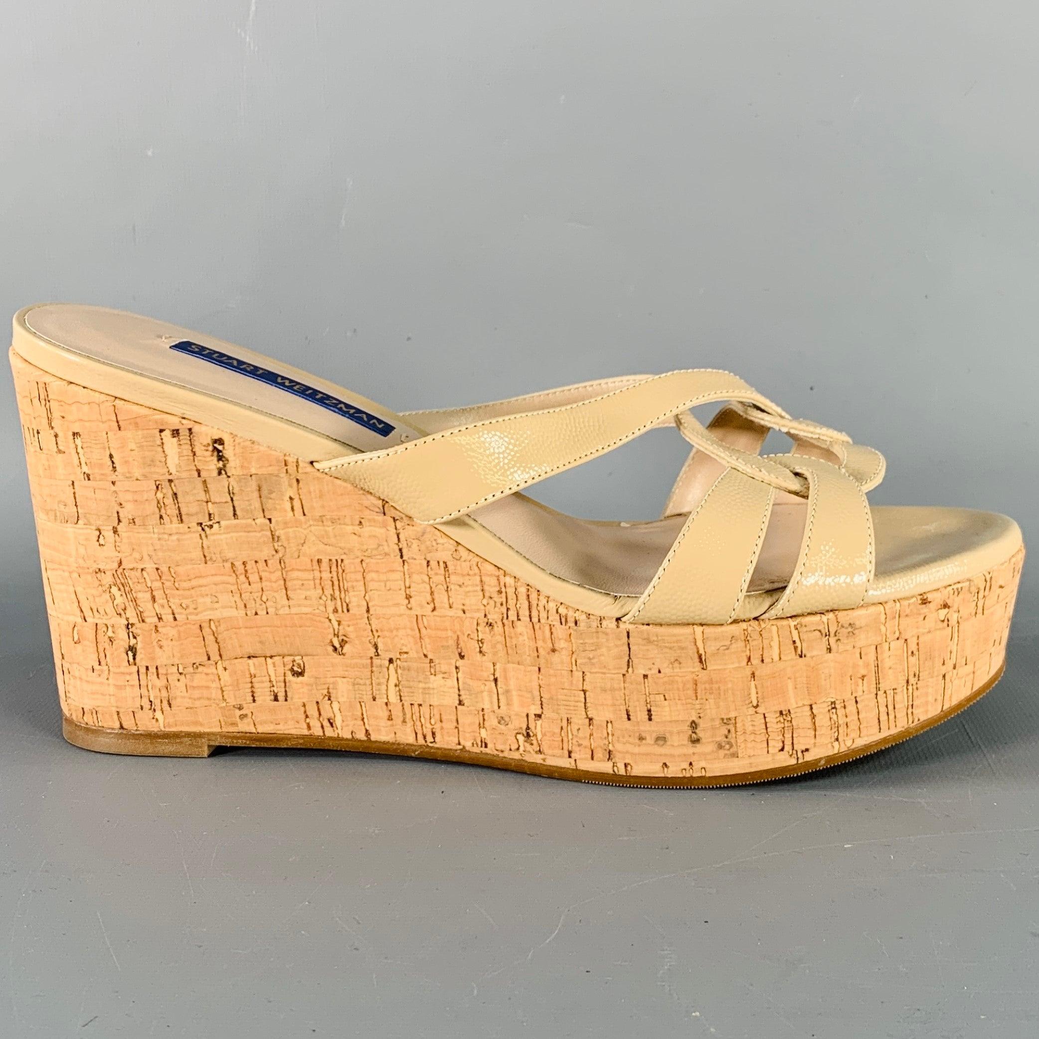STUART WEITZMAN sandals
in a beige textured material featuring a wedge style with cork platform design, and slip on closure. Made in Spainches Excellent Pre-Owned Condition. 

Marked:   Z W63532 7 M 

Measurements: 
  Heel: 3.5 inches Platform: 1.25