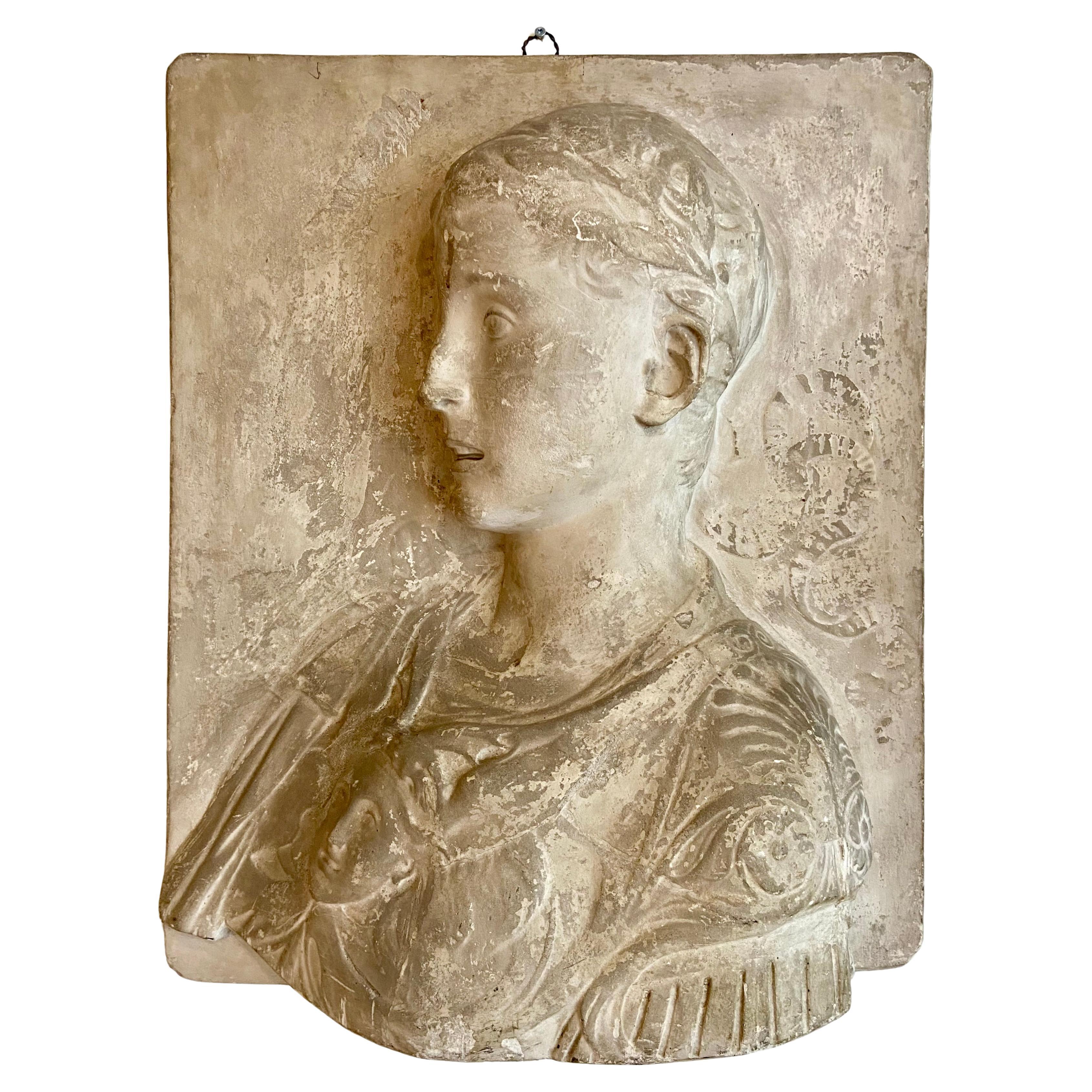 Stucco bust of a young roman emperor in relief.
