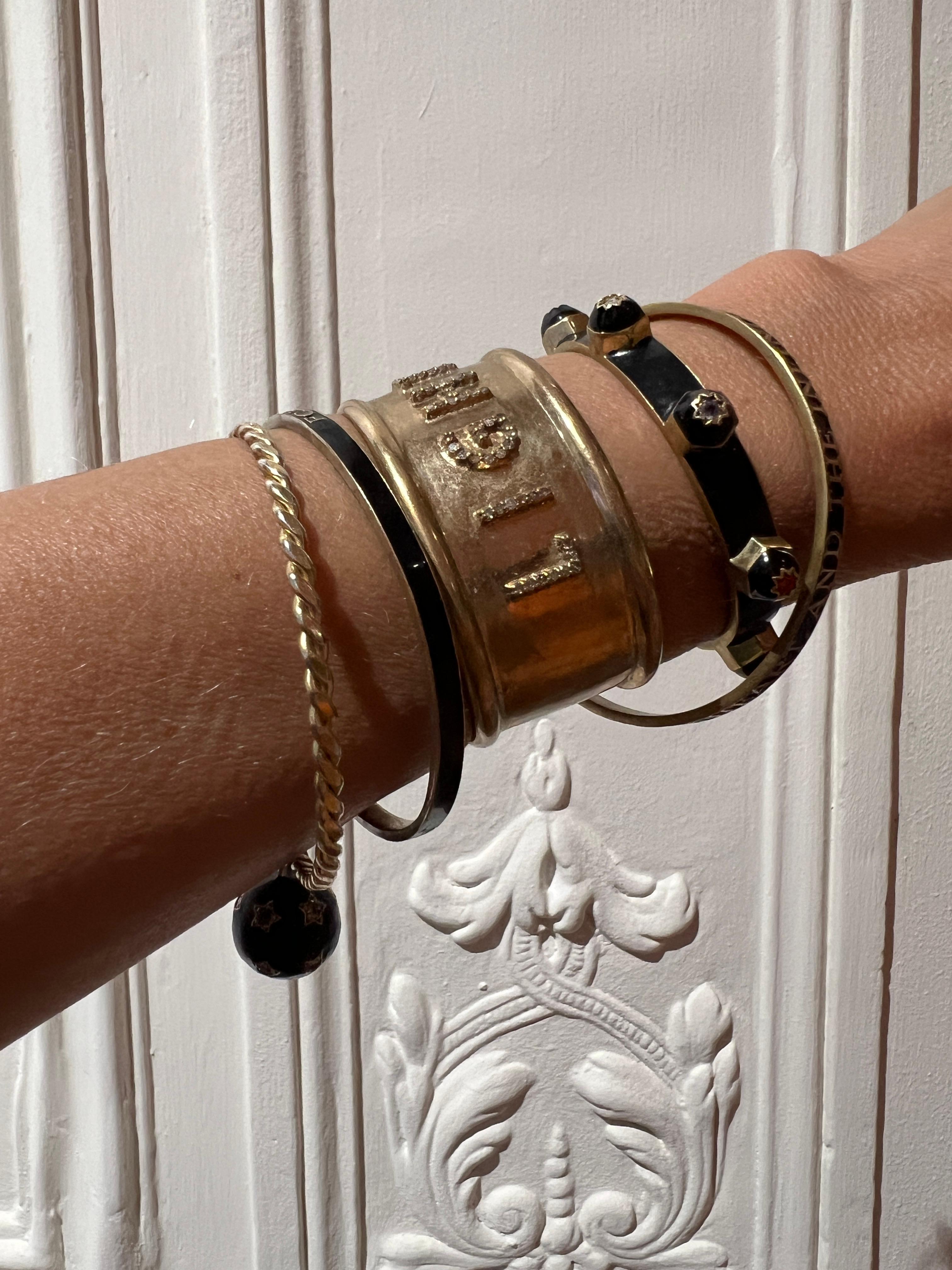 Dieses kühne Armband von J DAUPHIN aus schwarzer Emaille ist aus 14-karätigem, vergoldetem Messing handgefertigt und mit sieben natürlichen Edelsteinen besetzt, die jeweils einem Chakra zugeordnet und mit achtzackigen Sternmotiven graviert sind.