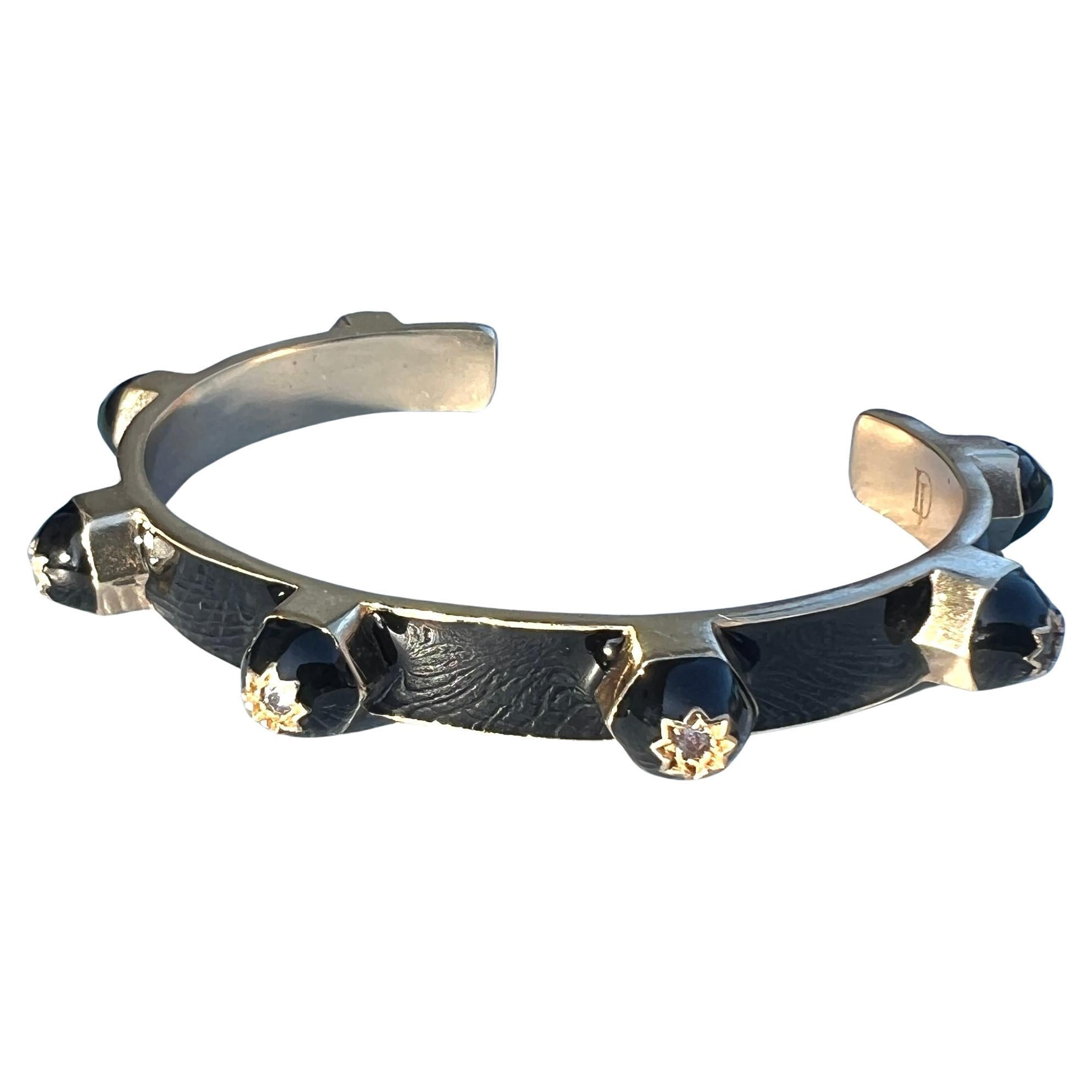Bracelet manchette émail noir Tanzanite Description

Le bracelet manchette en émail noir et tanzanite est une pièce d'apparat frappante, fabriquée à la main, qui allie le symbolisme sacré à un design sculptural moderne. Réalisée en laiton plaqué or
