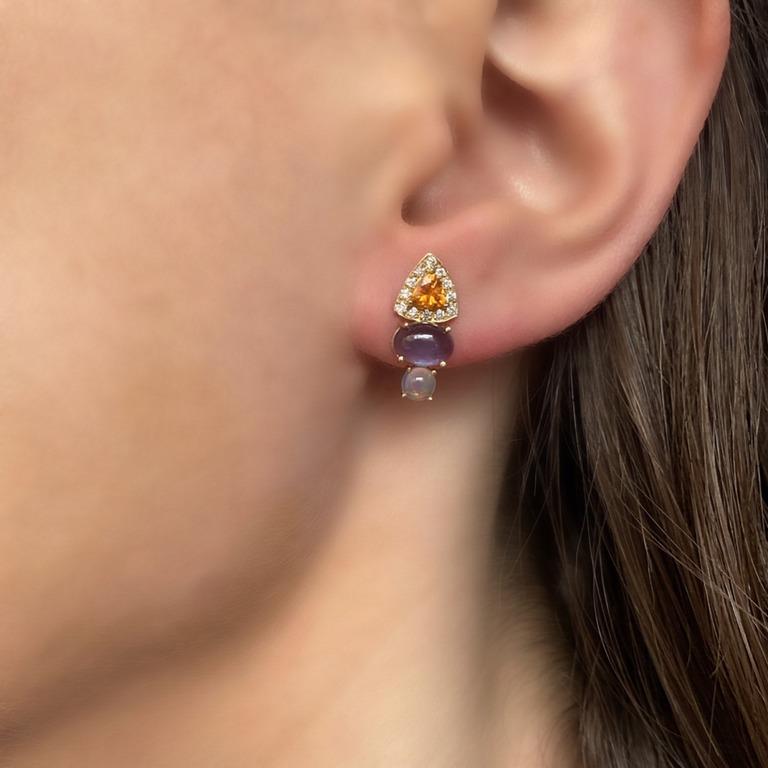 This stud earring is unique in both the elongated shape and unusual mix of color.  Cool Tanzanite and Opal are offset by the warmth of Spessartite trillions, surrounded by white Diamonds.  This will be a favorite earring in your wardrobe.
Materials: