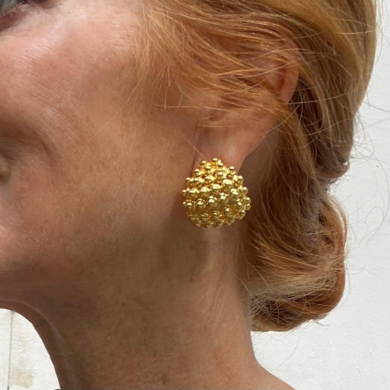 Orecchini bombe con borchie a metà cerchio estremamente eleganti e insoliti. Gli orecchini a forma ovoidale sono formati da dischi d'oro cabochon interconnessi, ognuno dei quali è sormontato da una perla sferica d'oro più piccola. Splendidamente
