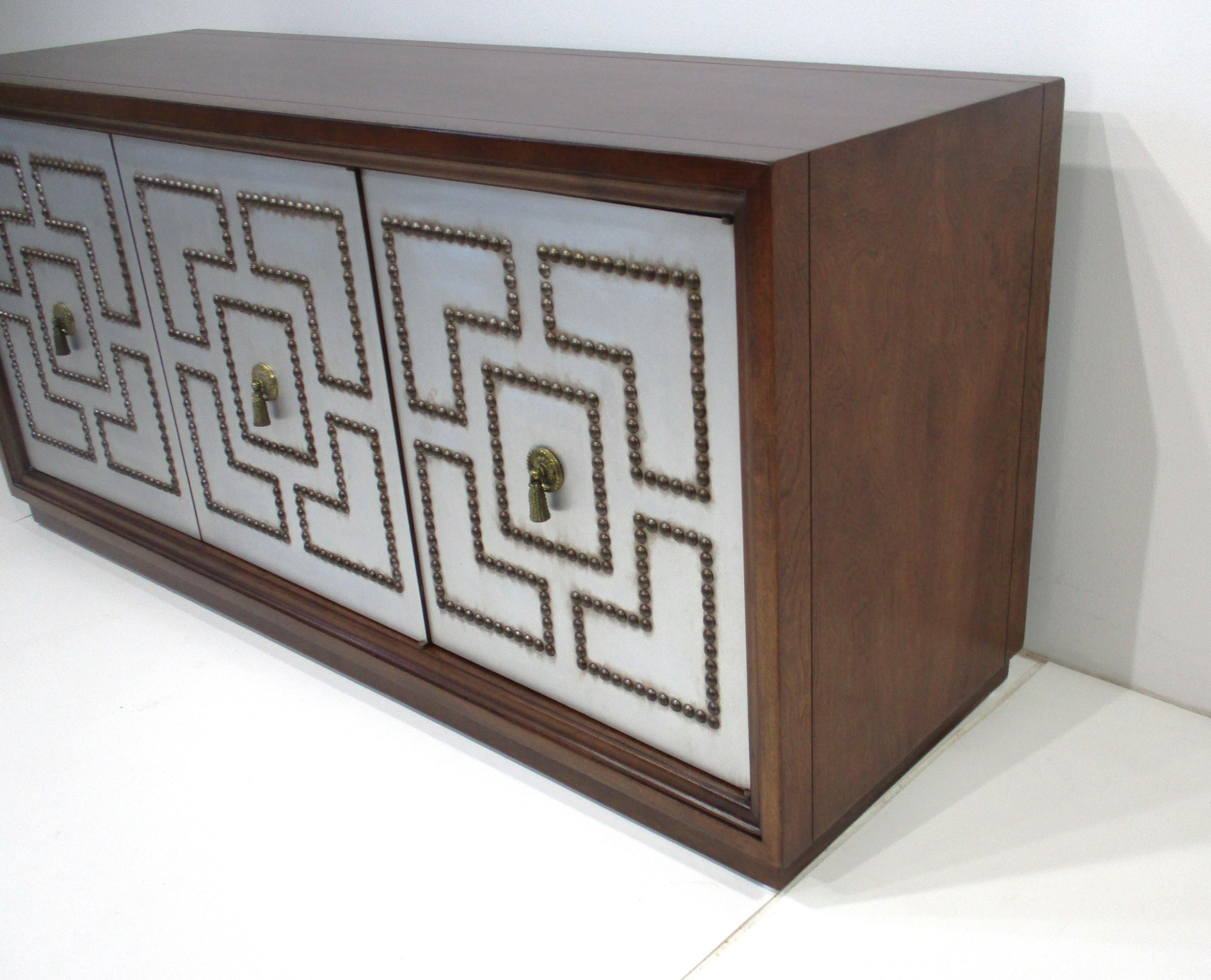Crédence à trois portes en noyer foncé, unique en son genre, datant du milieu du siècle dernier, avec des façades en métal appliqué, des clous en laiton et des poignées en forme de houppes en laiton moulé. L'intérieur est constitué d'une étagère