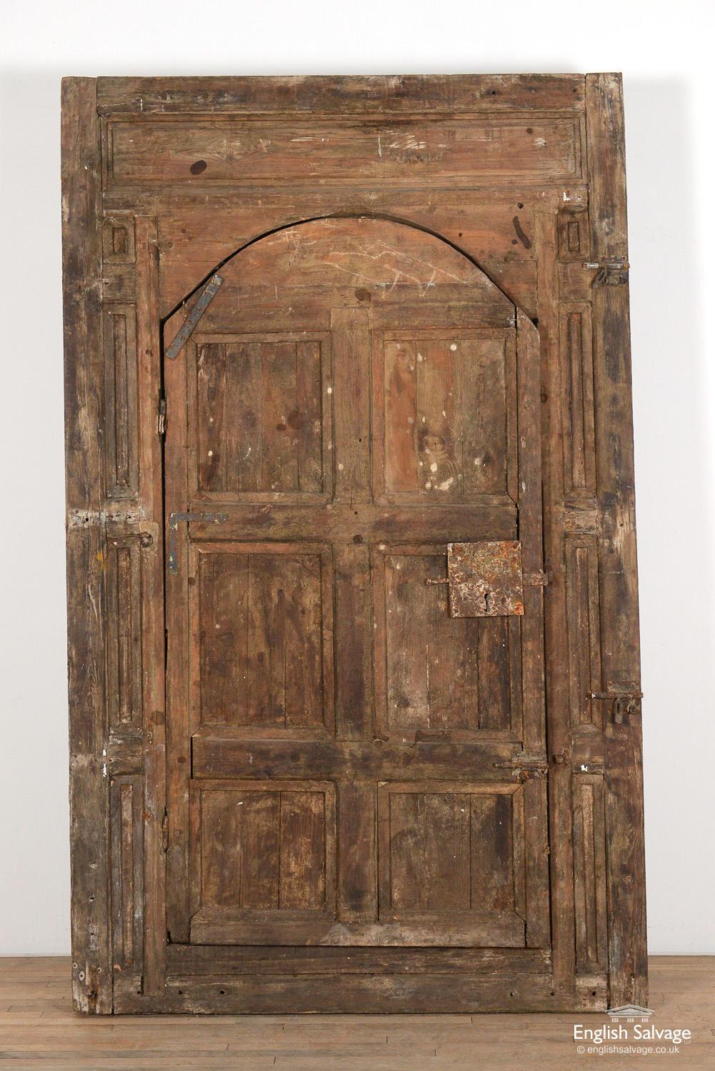 Old reclaimed wooden Moroccan door with an internal Judas door / wicket gate. Studded metal front with old ironmongary present. Splits and scuffs commensurate with age with some work required to be hung as a door. Inner door measures 97cm x 186cm x