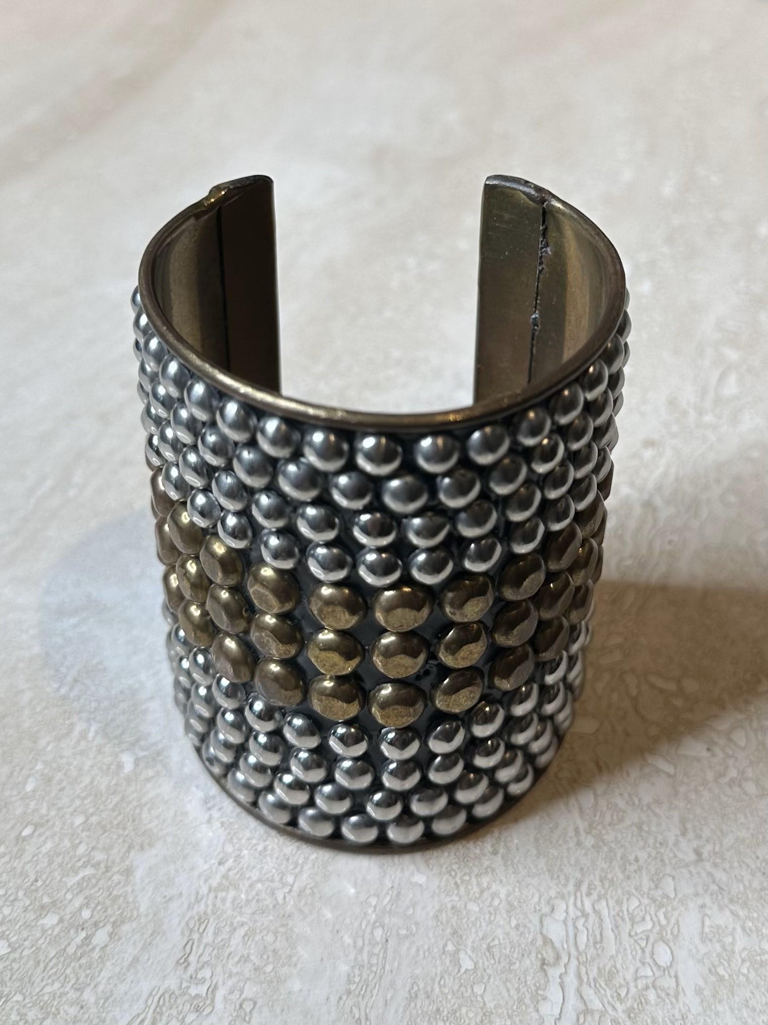 Il bracciale Studded Silver & Brass è un pezzo audace e dinamico che combina la bellezza contrastante dei metalli argento e ottone con il fascino tagliente delle borchie. Il suo design industrial-chic lo rende una scelta eccellente per una varietà