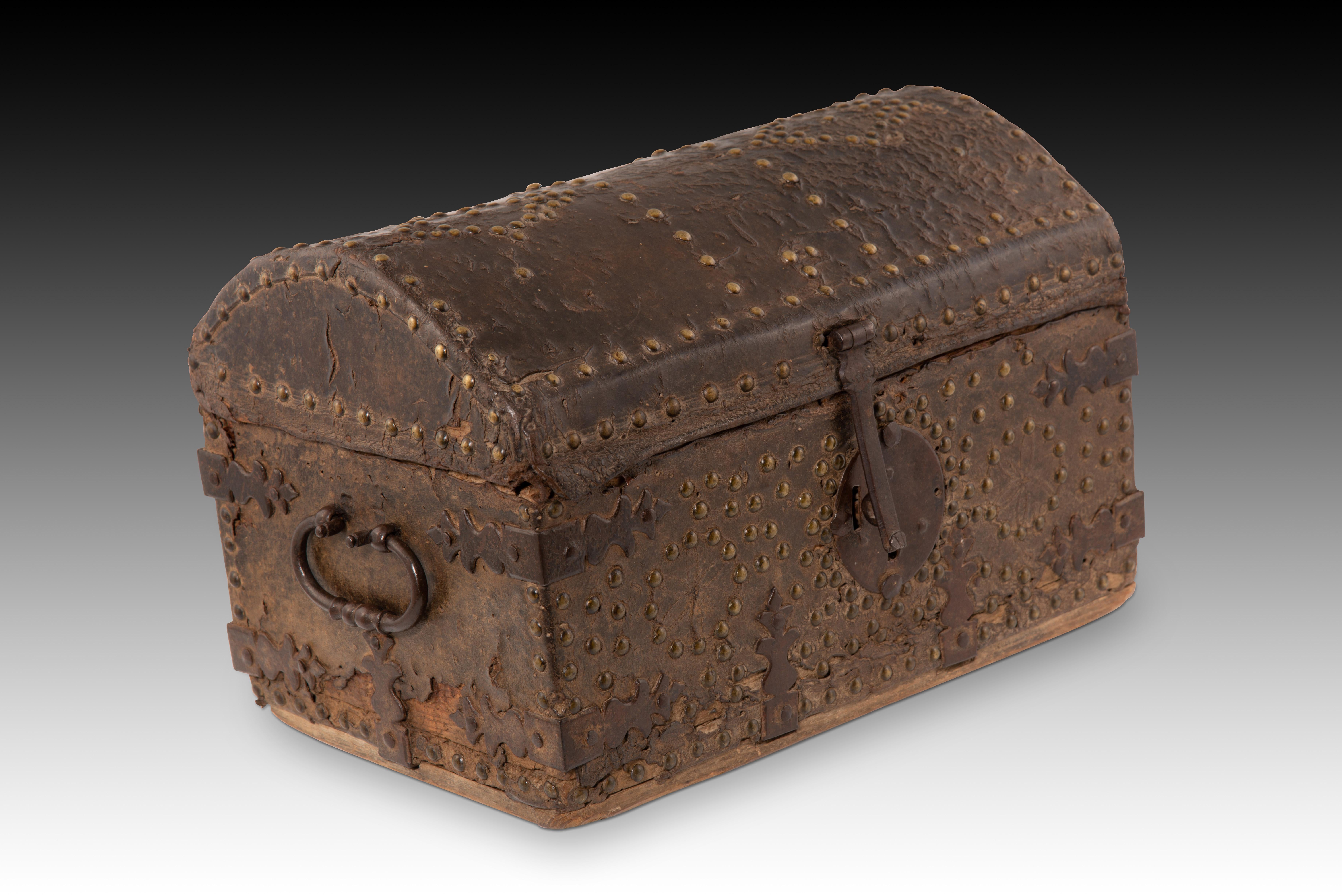  Tronco tachonado. Madera, cuero, metal. España, siglo XVIII. 
Pequeño arcón o baúl de base rectangular y tapa curva, decorado exteriormente con una funda de cuero y una serie de tachuelas metálicas formando líneas y motivos geométricos sencillos,
