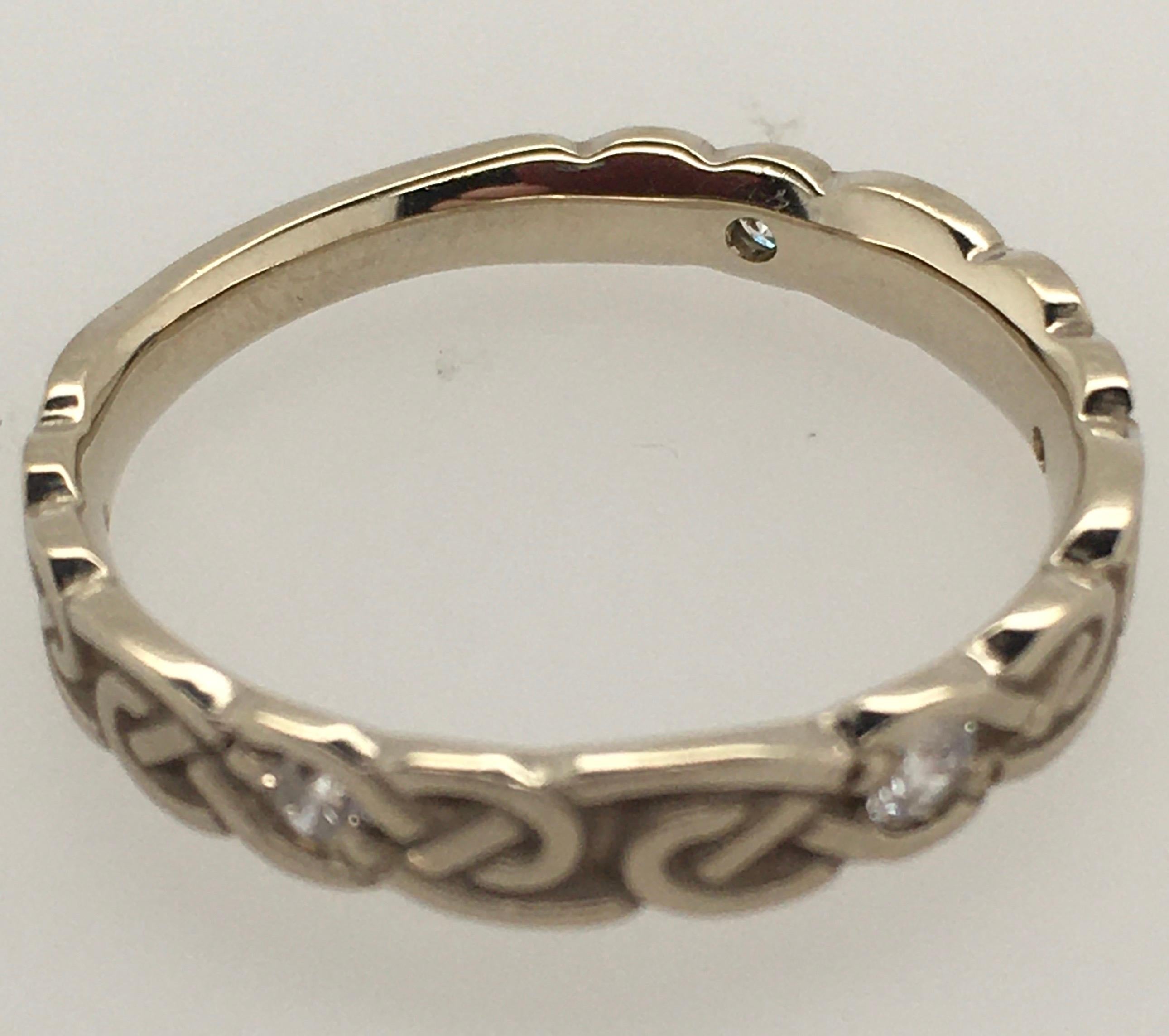 This Studio 311 women's 14K white gold band is a striking example of their Borderless Narrow Infinity Knot design. Light oxidation highlights its intricate detailing. The Comfort Fit band is set with 5 diamond accents (.18 TCW) within the infinity