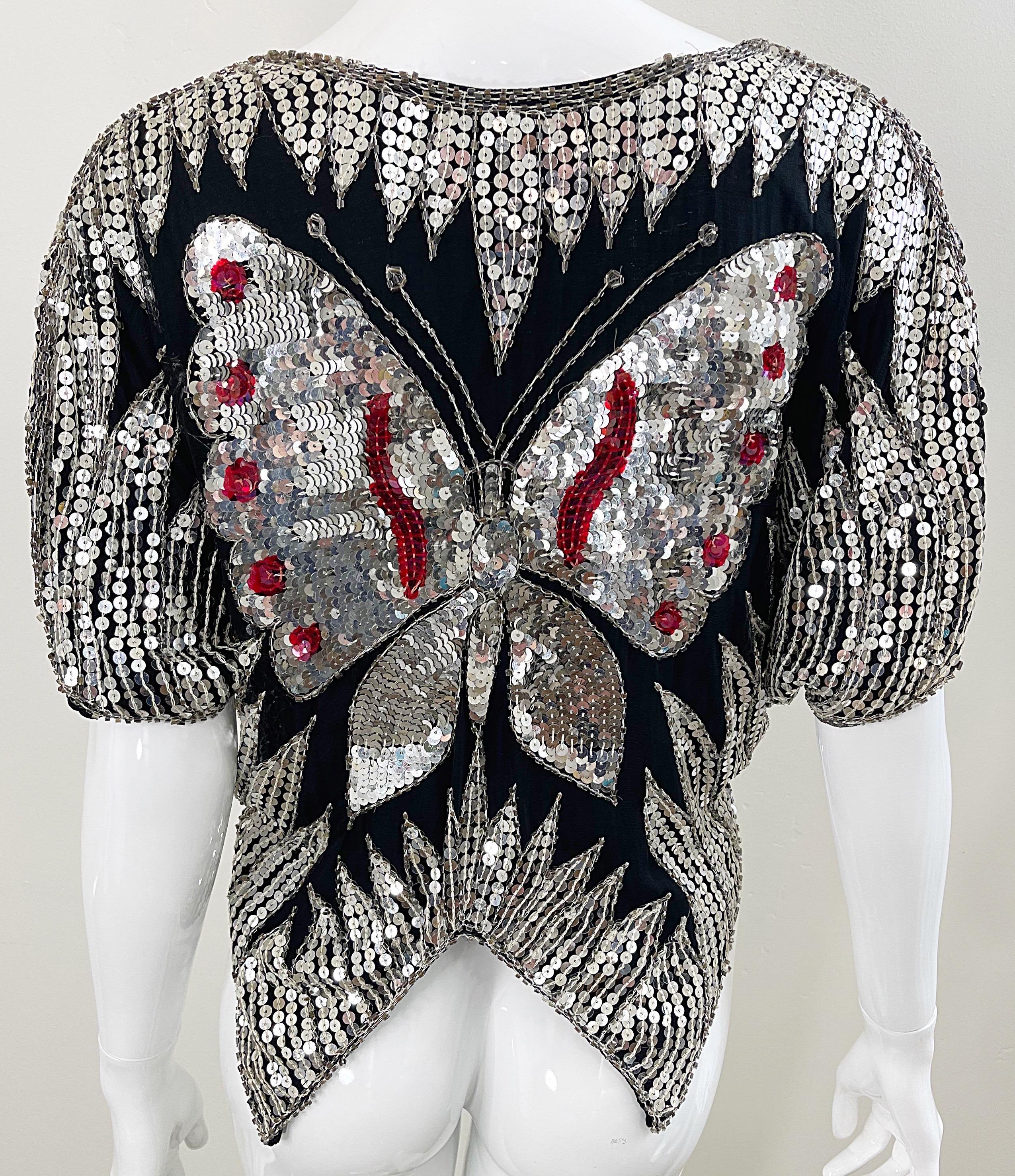 Amazing early 80s black, red and silver sequin and beaded butterfly dolman sleeve silk blouse ! Thousands of hand-sewn sequins and beads throughout. Simply slips over the head. Pair with jeans, trousers or a skirt. 
In great condition 
Approximately