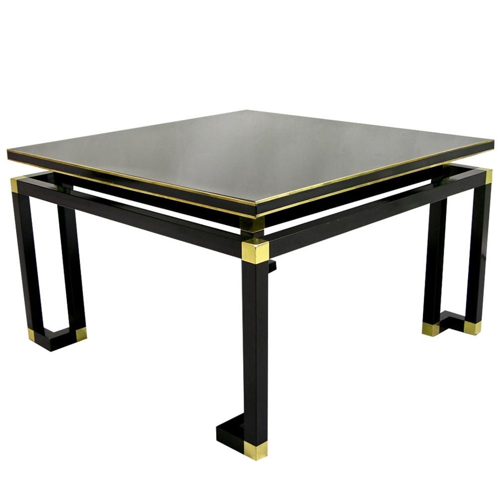 1970 Italian low side table in black lacquered wood and metal details by Italian Company Studio A, with airy Minimalist and clean design. The top is raised on a sleek double framed geometric leg structure with brass highlights set in contrast to the