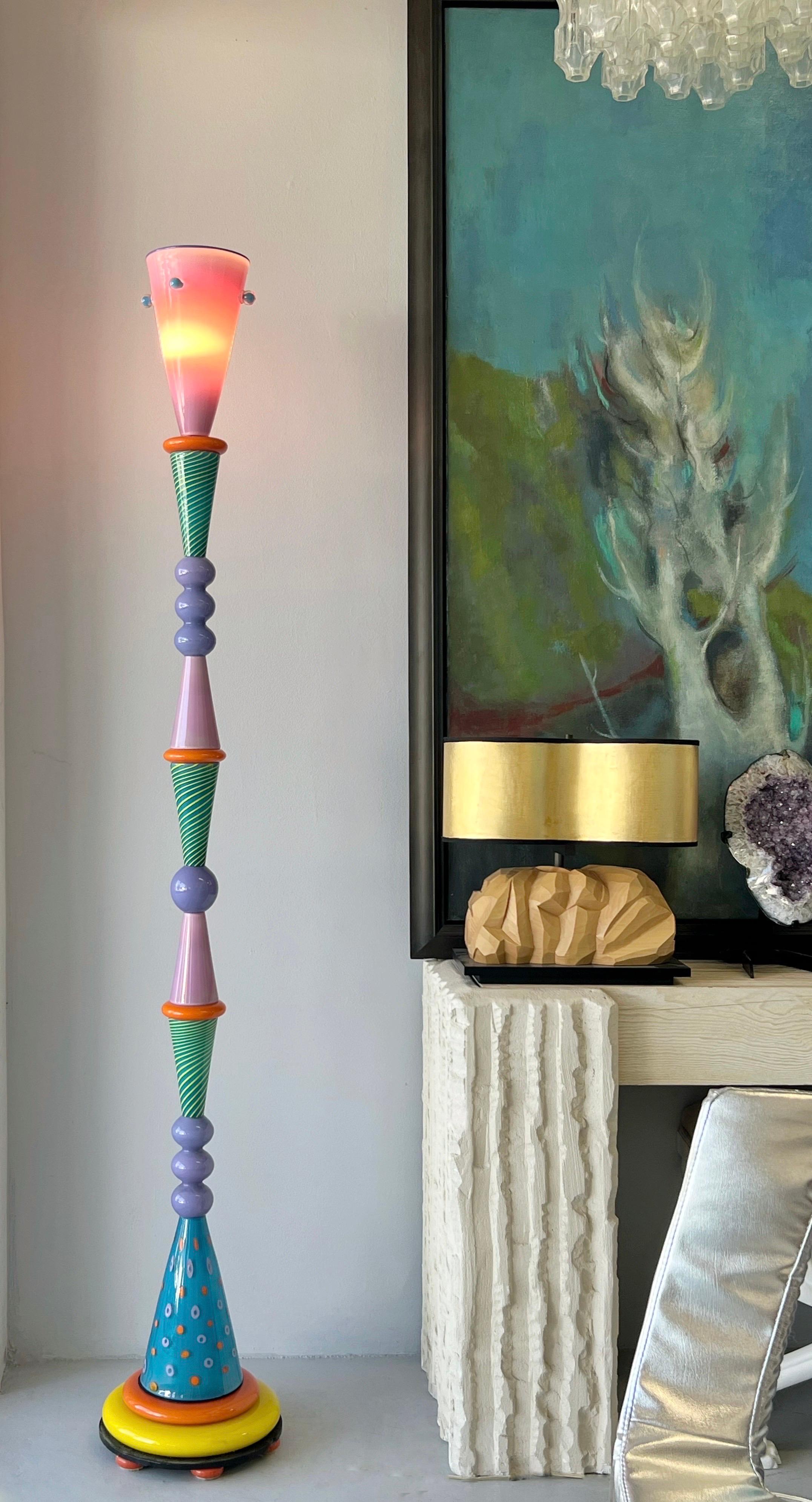 This is very tall art glass floor lamp, signed and dated 1991. The designed is graphic and colorful. Very much in the style of Memphis. Quality is extraordinary. Signature illegible.