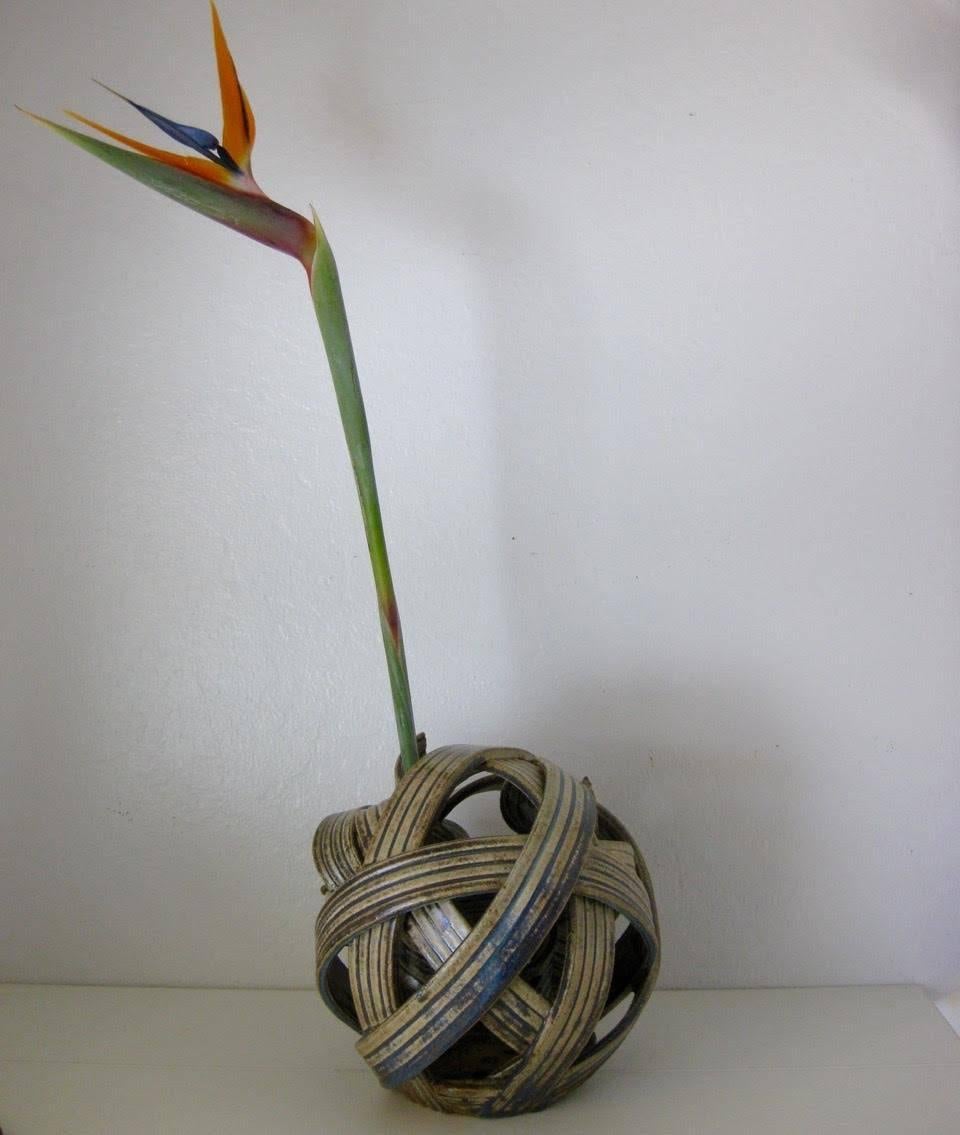 Unusual sculptural studio art pottery Ikebana ribbon orb vase. Works as a sculptural piece on its own or as a sculptural vase for dramatic Ikebana flower arrangements. The piece has four spiralled bands on the inside of the orb to hold tall-stemmed