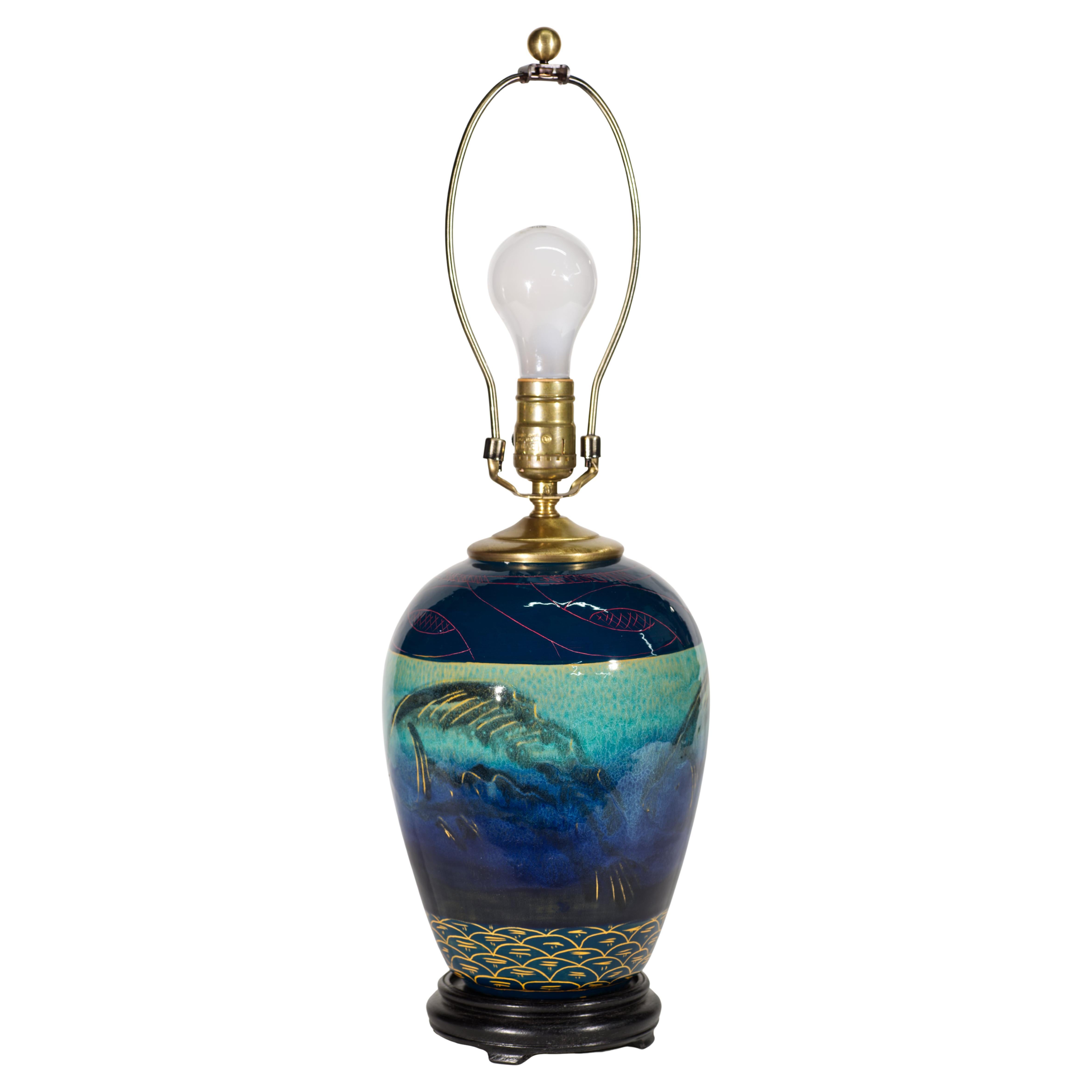  Rare vintage studio pottery lamp features complex hand-painted decor on white ceramic or porcelain body. The design explores underwater environment with marine imagery used in all parts of decor. 

The main decor on the ceramic body is accented by