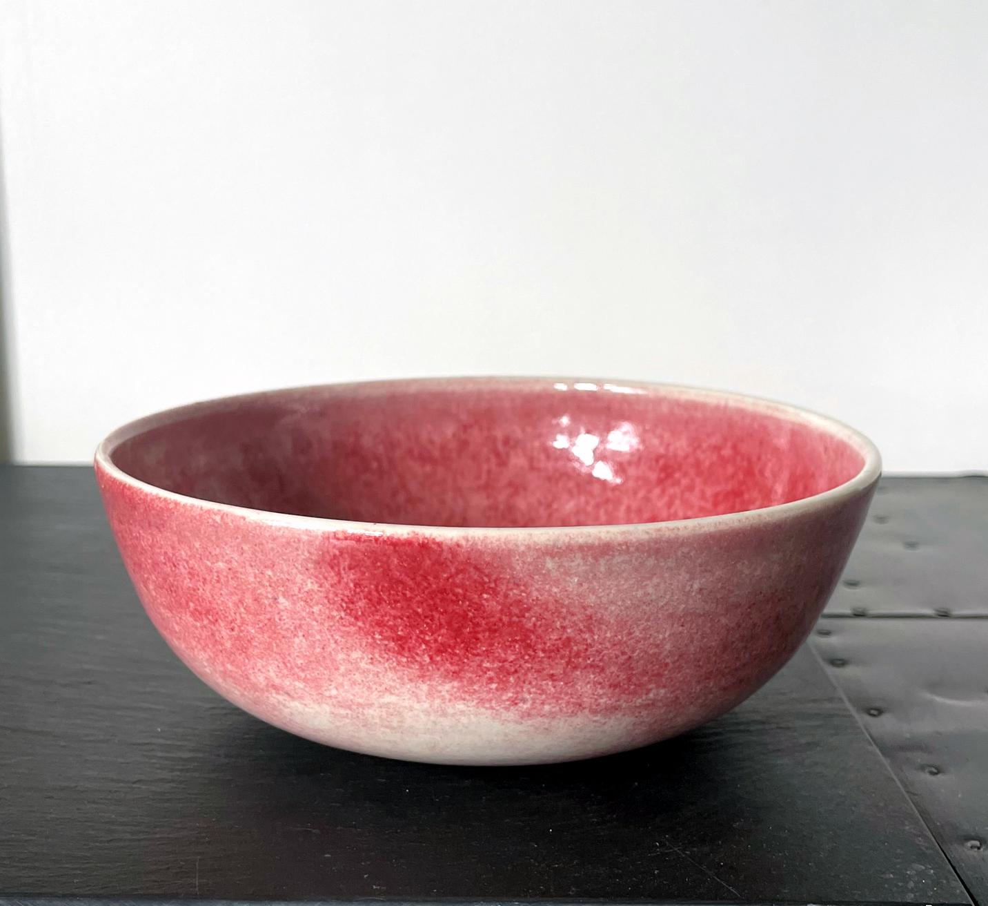 An early ceramic round bowl with a flat foot ring studio crafted by Brother Thomas Bezanson (1929-2007) circa 1970-80s. Covered in a brilliant free form red glaze on white background, the bowl has the root of its archetype in Chinese ceramic and the