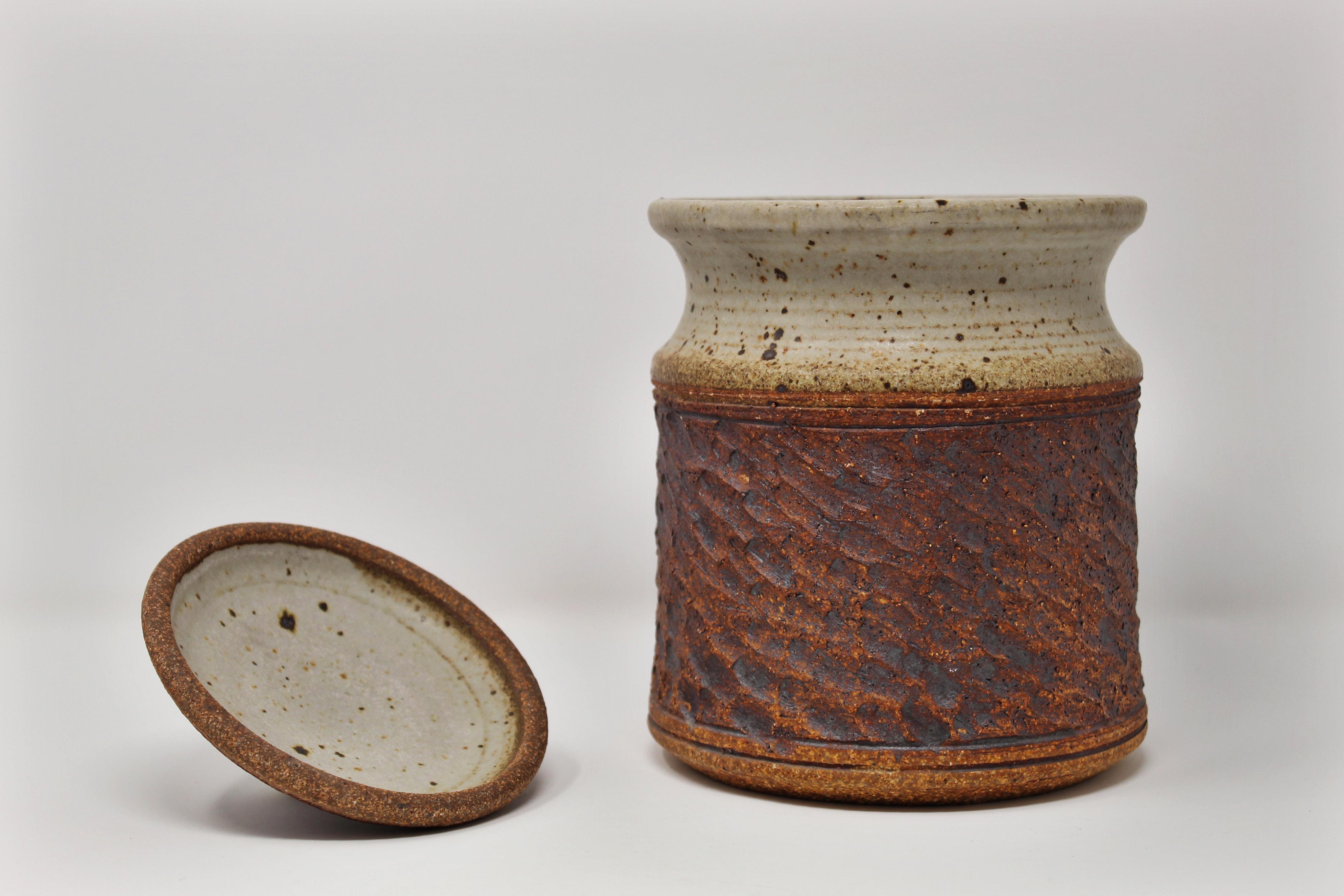 Beautiful Studio Pottery ceramic vessel with lid. Exceptional earth tones and great combination of texture. Very nice midcentury California design decorative object.
   