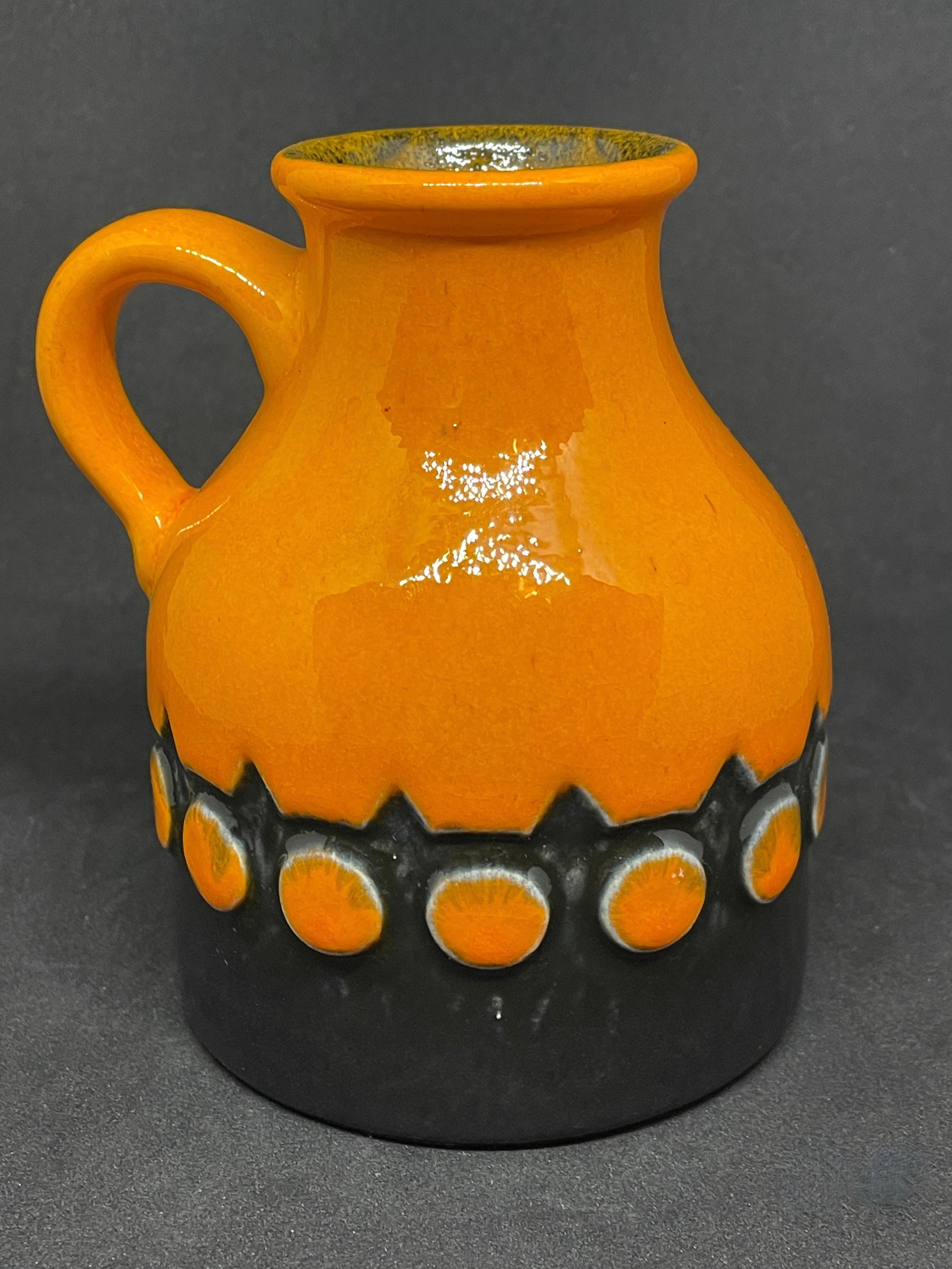 An amazing midcentury studio art pottery vase with orange and brown lava glaze, Germany, circa 1970s. Vase is in very good condition with no chips, cracks, or flea bites. Signed with a number at the base and manufactory logo.