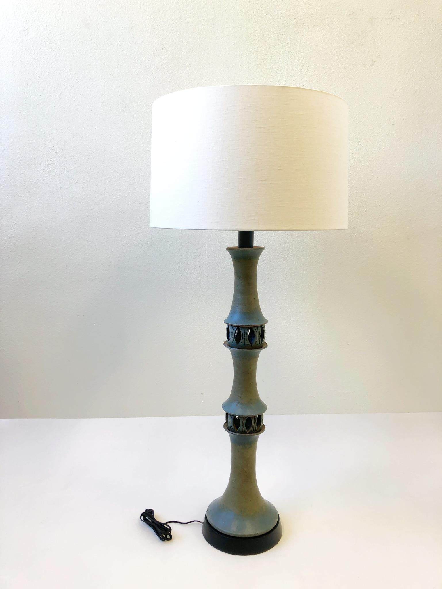 A spectacular studio ceramic floor lamp by renowned ceramics Raul Coronel. The lamp is constructed of ceramic sections, black lacquer wood, newl polish nickel hardware and new vanilla linen shade. 
Dimensions: 54.5” high 24” diameter 11” diameter
