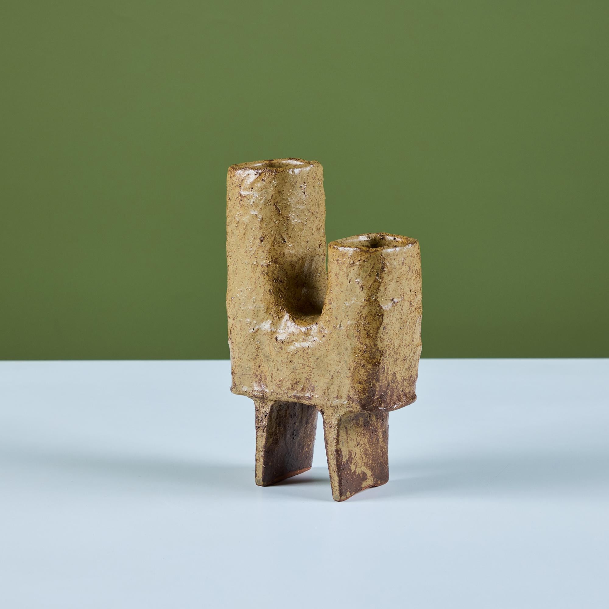 Un pezzo unico di arte ceramica che funge anche da recipiente. Presenta uno smalto ocra testurizzato e una forma a 