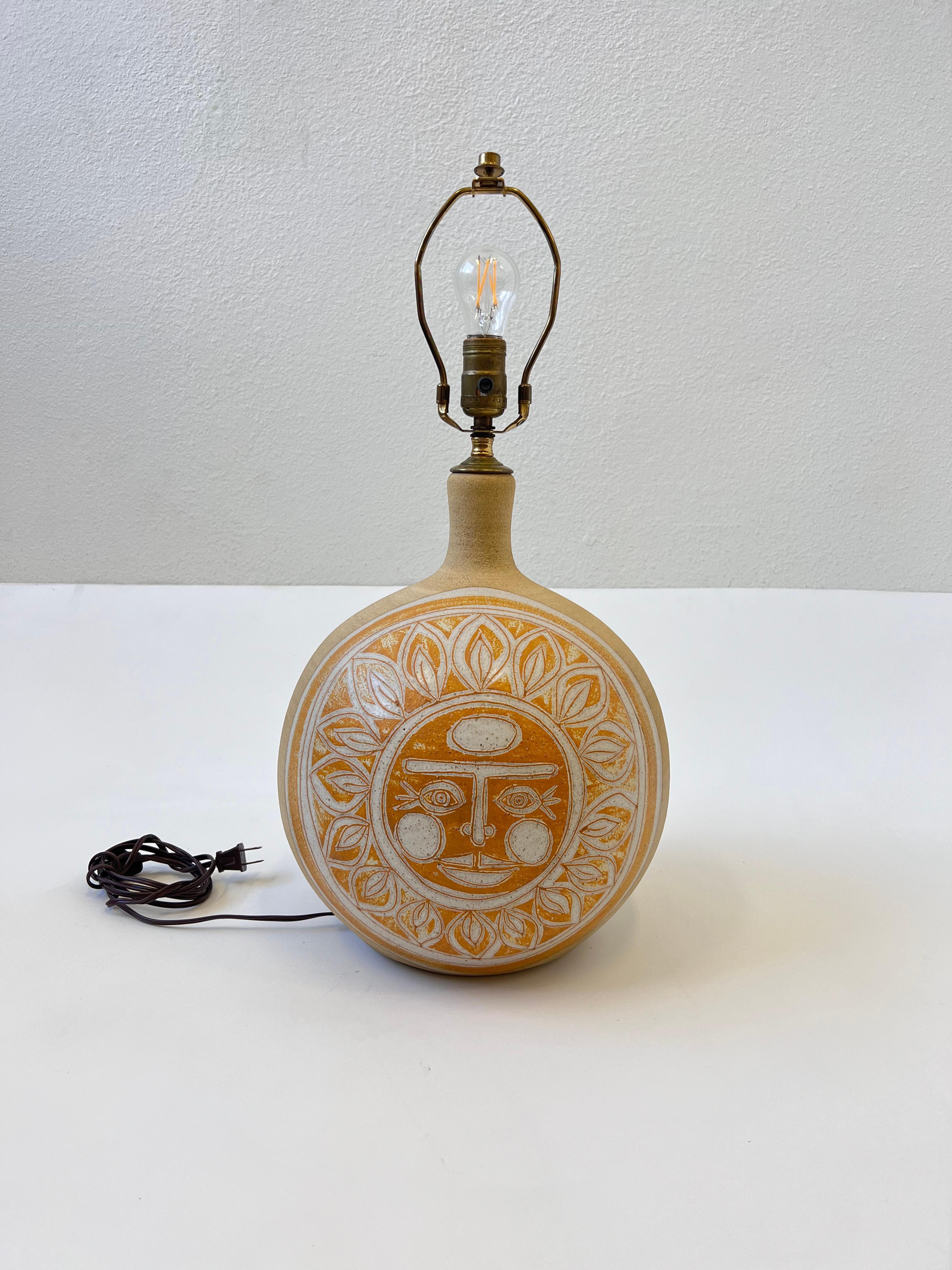 Studio ceramic table lamp with two sun faces from 1977 by Brown. 
Newly rewired with new wire and socket. The brass has an aged finish and shade is vanilla color linen. 
It takes one 75w Max Edison light bulb. 

Measurements: 24.5” High, 20”