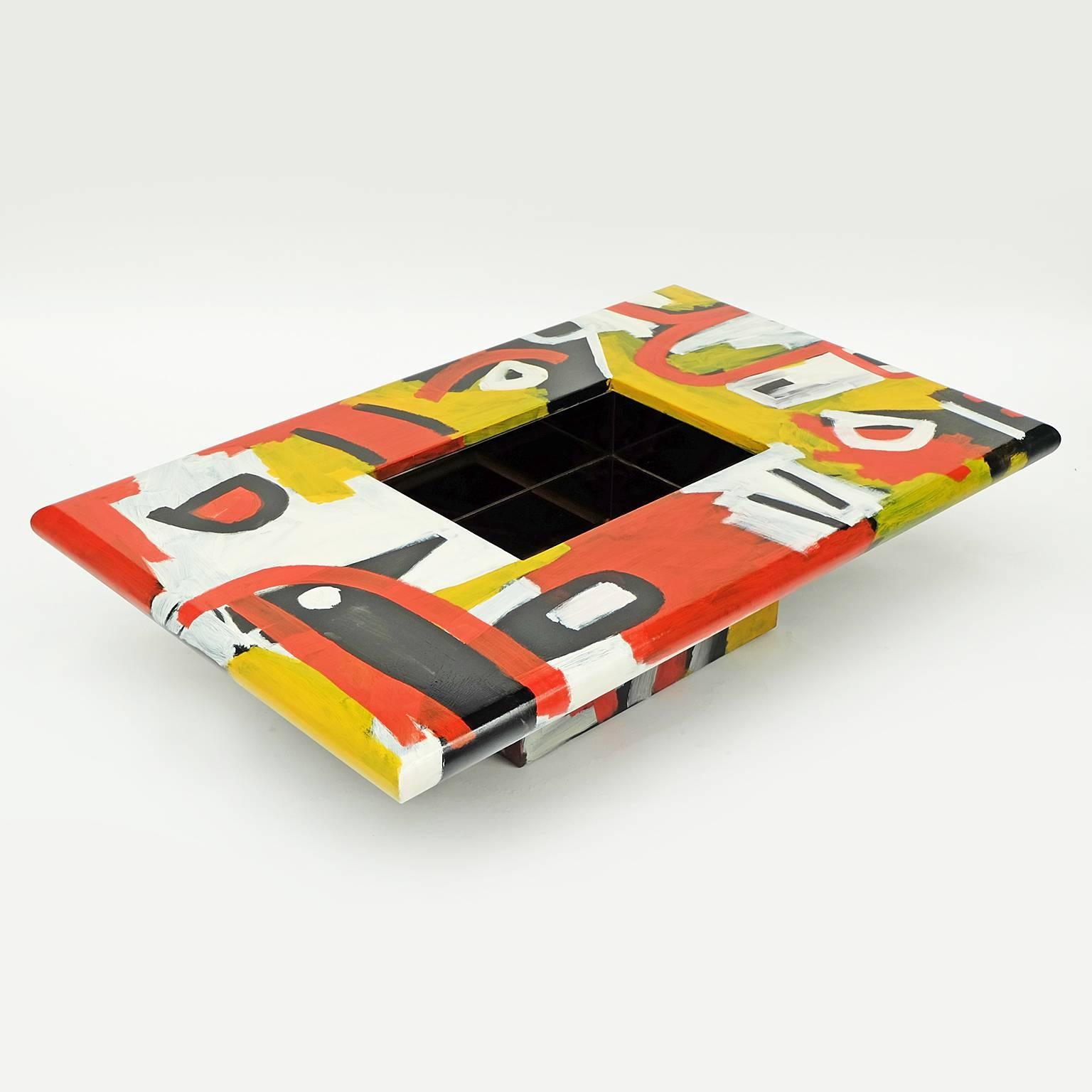The studio coffee table is a bespoke piece created by the artist Alan Fears. 

The table features a hand painted freeform tribal design.
Central tinted mirror storage. 

Measures: H 33cm x L 137cm x W 87cm.