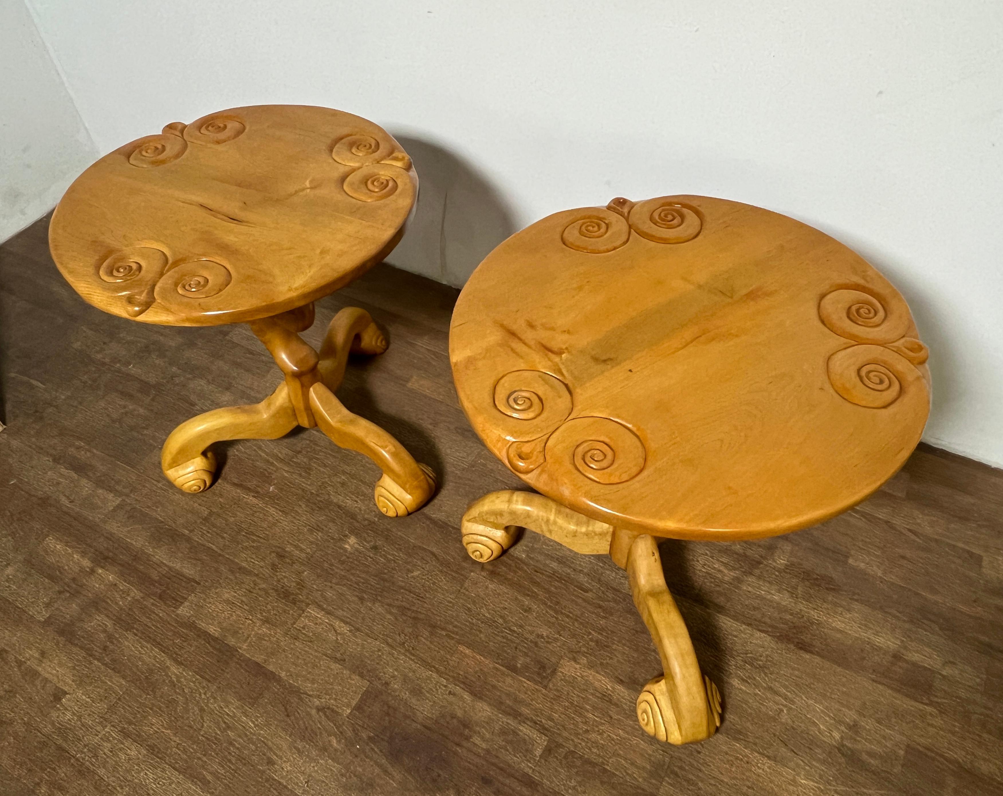 A unique pair of studio craft tables in carved and shaped maple from 1977. With scrolled club feet and anthropomorphic top carvings, these echo many of the whimsical characteristics that were a signature feature of the 1970s art furniture movement