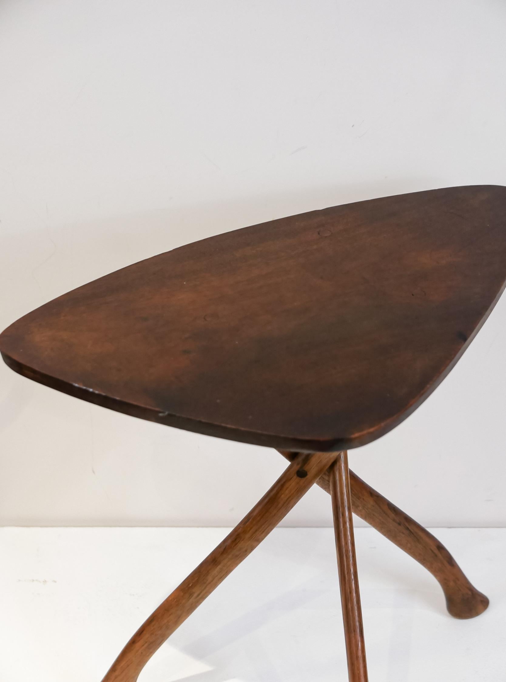 A remarkable little side table in a guitar pick form with three solid hickory axe handles as legs. From a Bucks County estate, unsigned- this table is very much in the style of Wharton Esherick. It was constructed with skill and has good age.