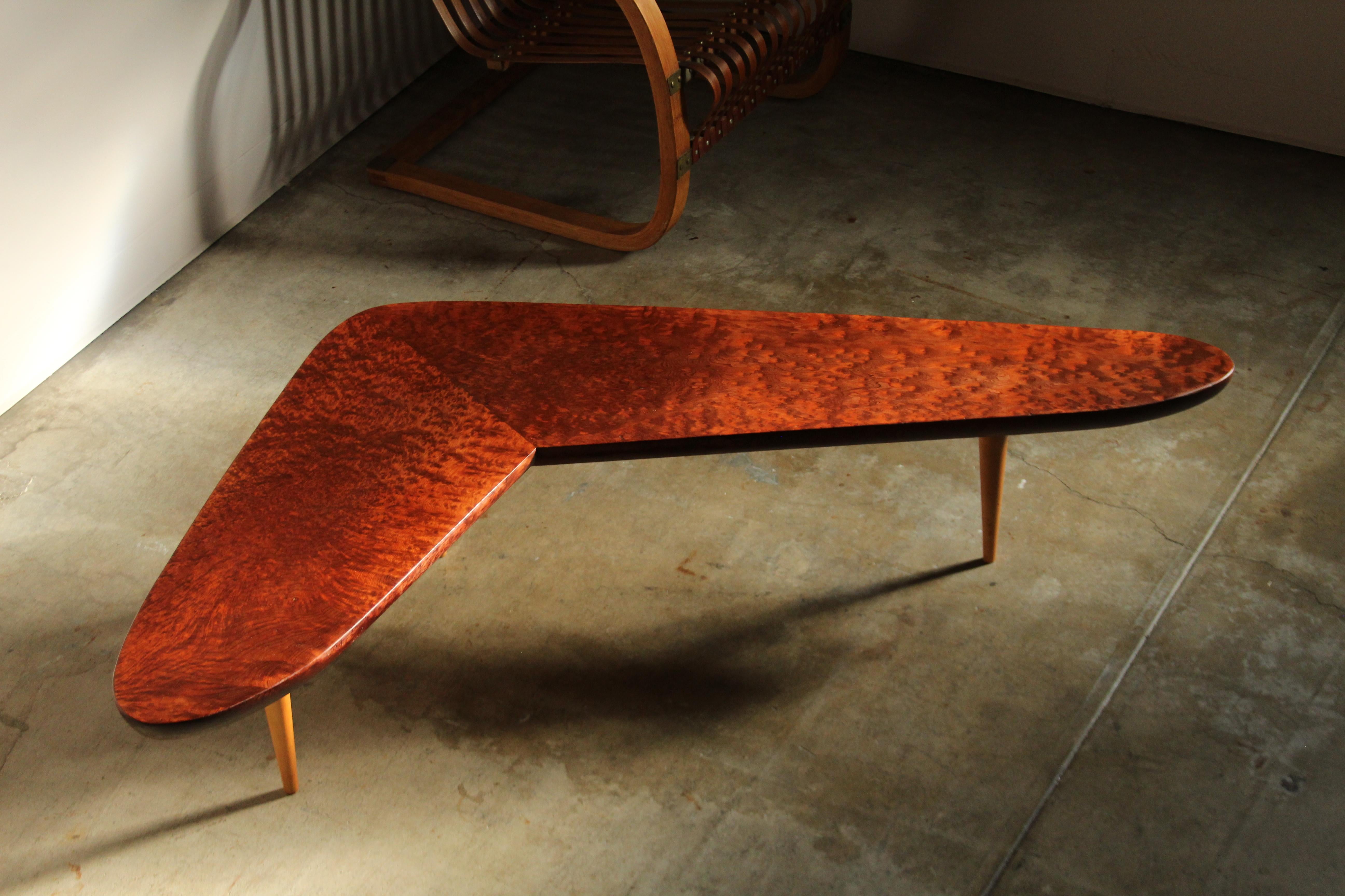 A striking, one-of-a-kind California studio craft coffee table made by an expert craftsperson in the 1950s. This beautiful table features a thick, solid redwood burl top with a tapered edge, and three tapered legs in solid maple with wonderful