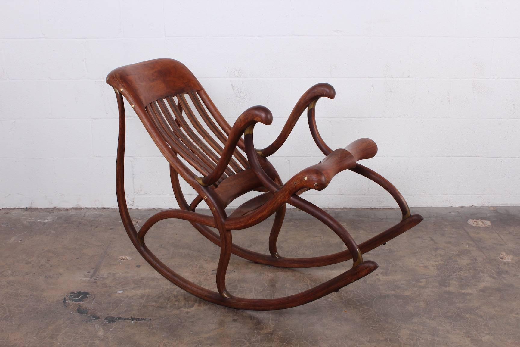 A beautifully crafted walnut rocking chair with bronze details. Crafted by David Crawford, 1988.
