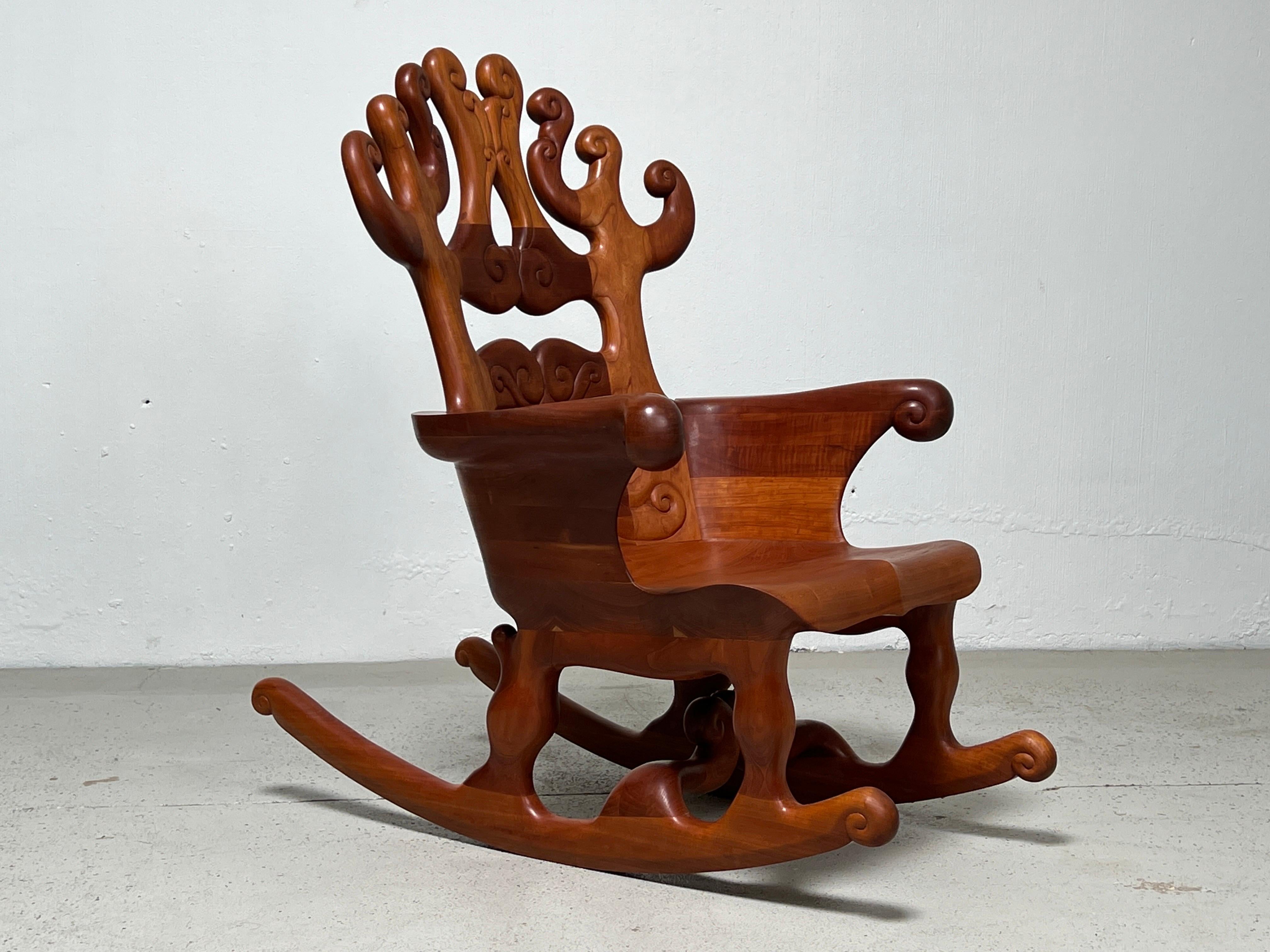 Carved rocking chair by California maker John Bauer. Employing stack-laminate cherry, this rocker represents a fine example of late 20th century studio craft furniture.