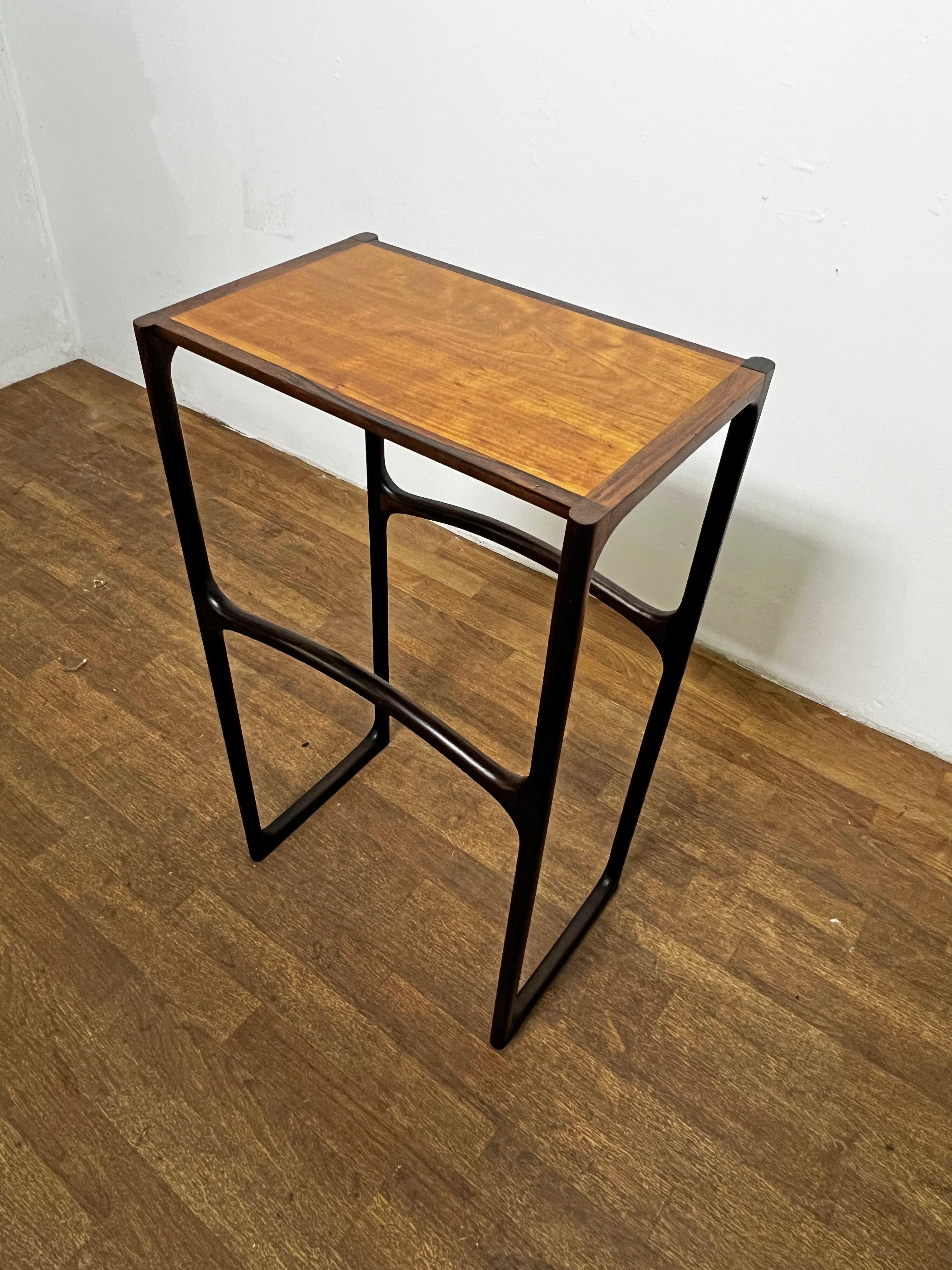 A sinewy pedestal table in rosewood and cherry by the noted studio craft furniture artisan John Bickel, dated 1985.