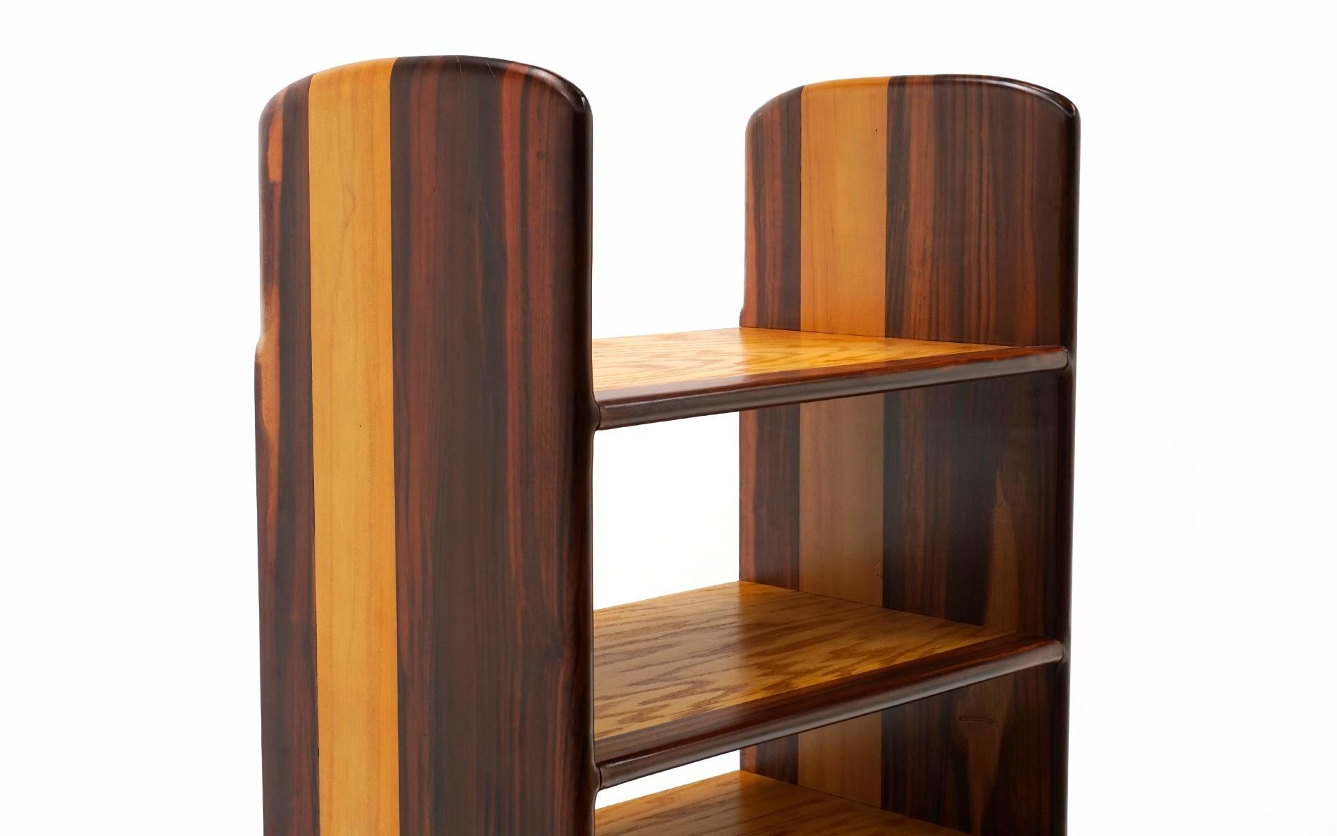 One of a kind studio craft bookcase made of Brazilian rosewood. Refinished and structurally sound. A good repair has been done to one of the 
