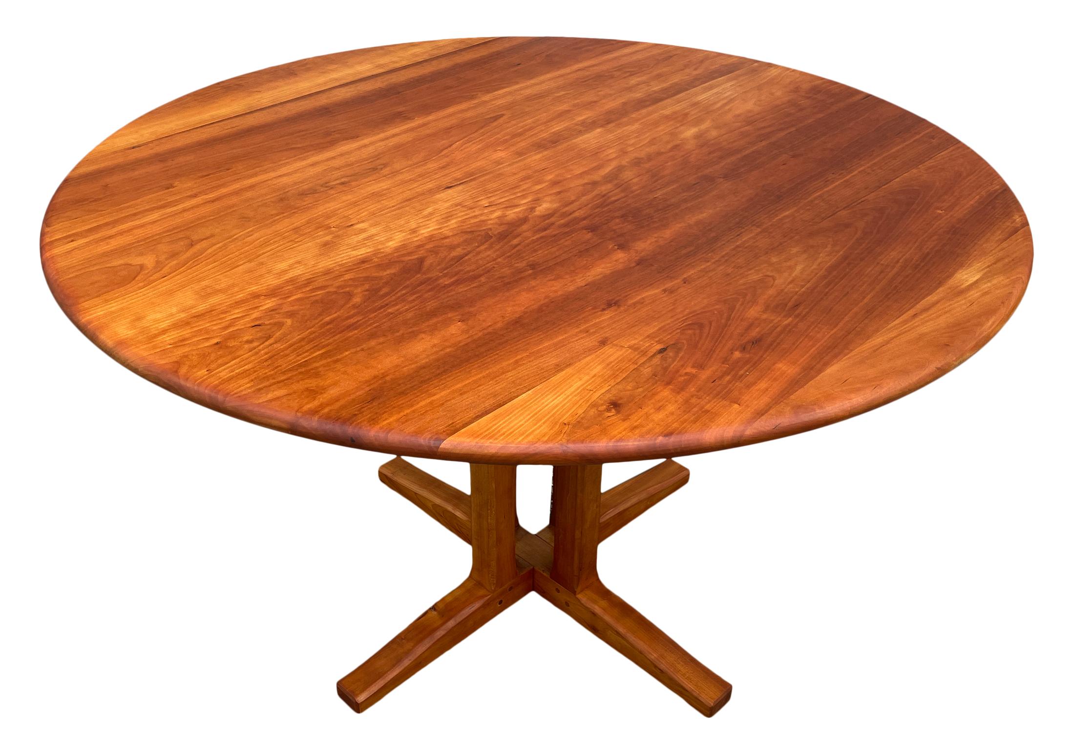 Stunning studio craft round solid cherry dining table by Charles Shackleton made in Vermont, circa 1997. Stamped - beautiful handcrafted dining table. Beautiful solid cherry cluster base and 1.250
