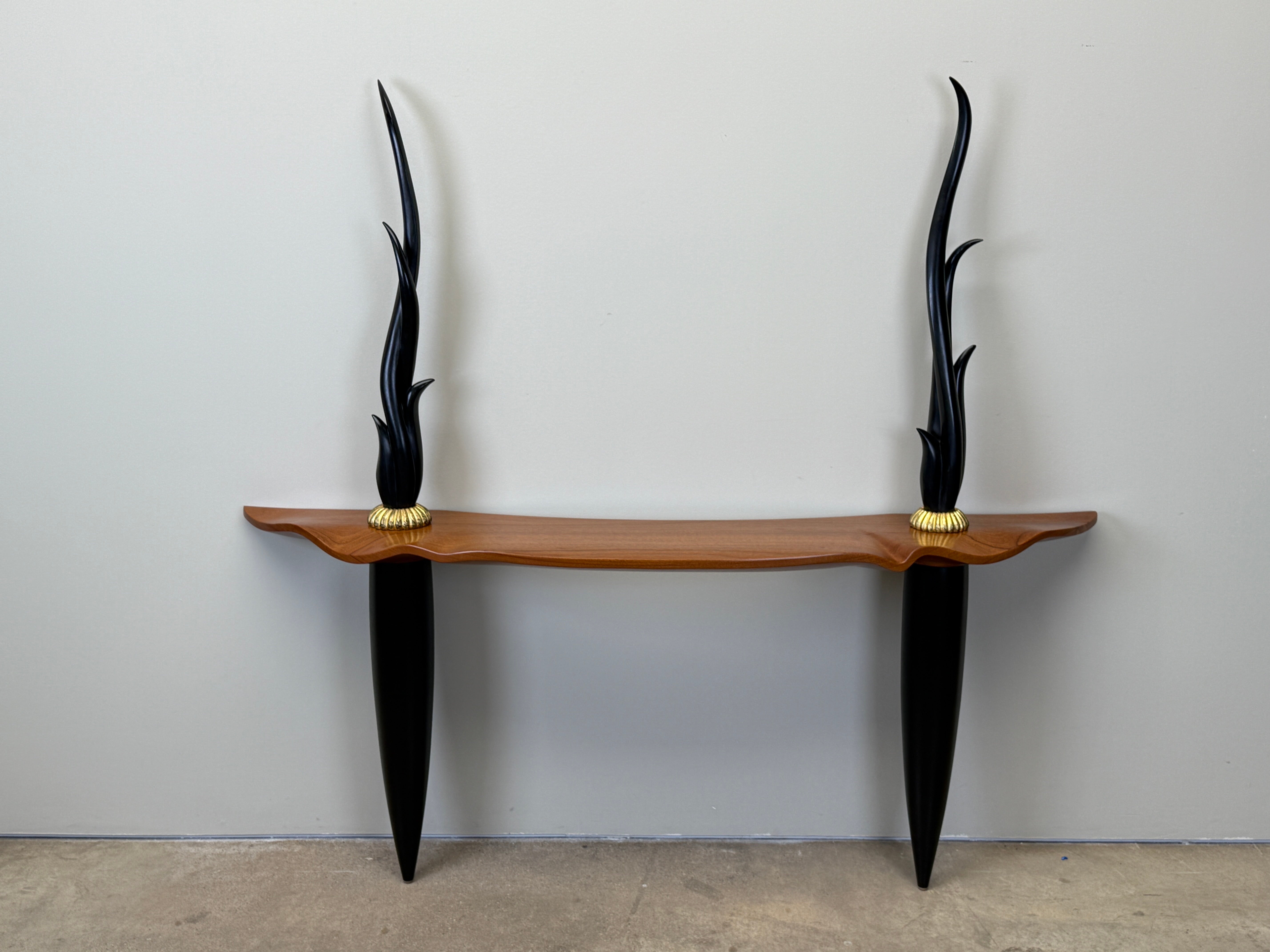 A solid cherry studio craft wall mount console with ebony legs and finials by Peter Dudley, 1993. 
Table height is 30