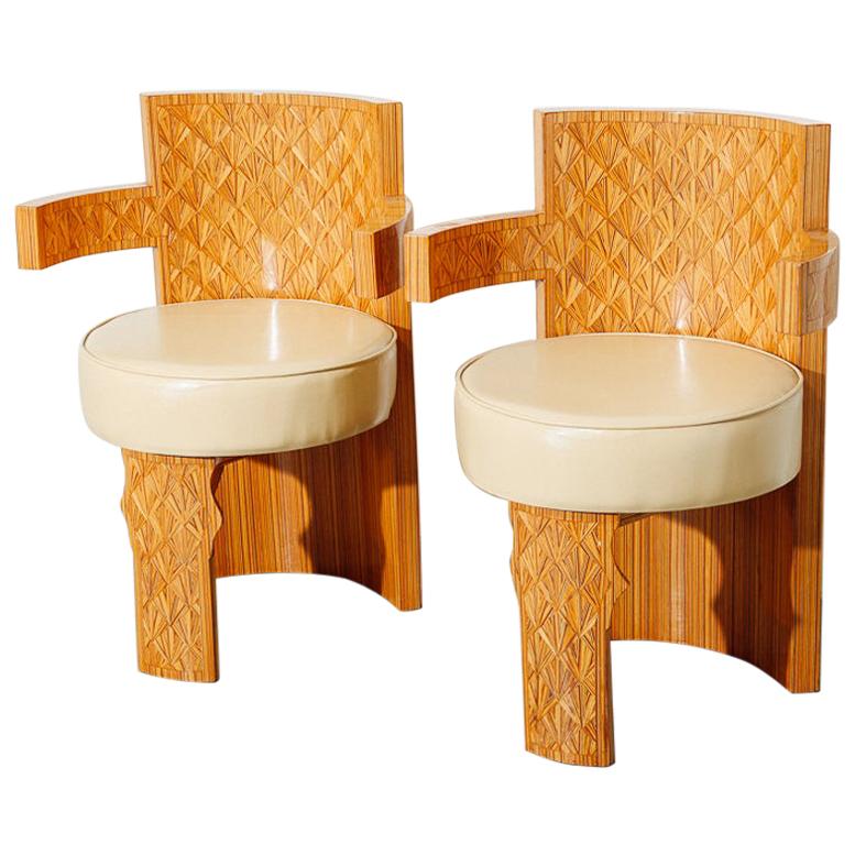 Barrel chairs with inlaid wood detail. Vinyl cushion seats.